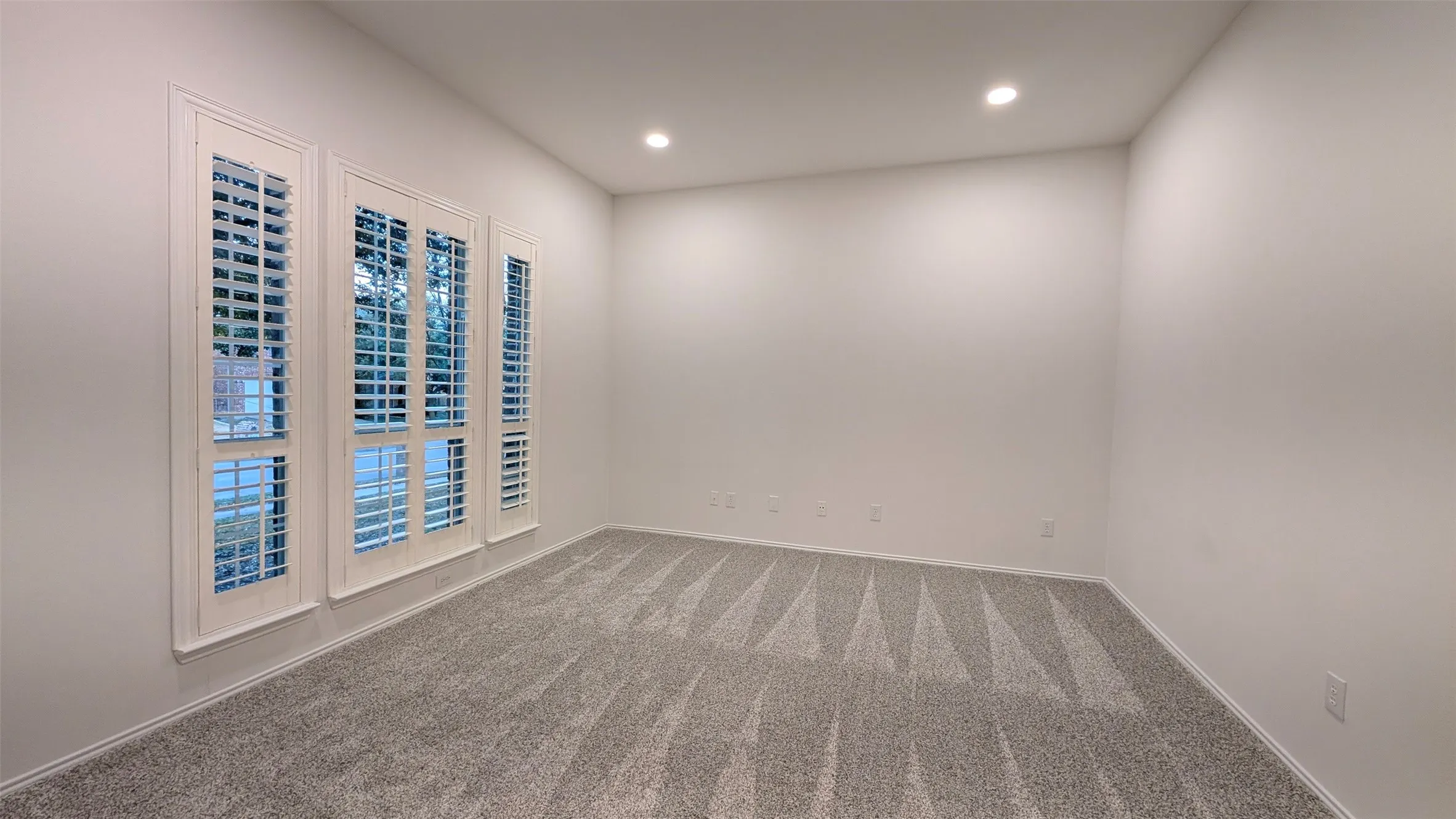Carpeted spare room featuring recessed lighting and baseboards
