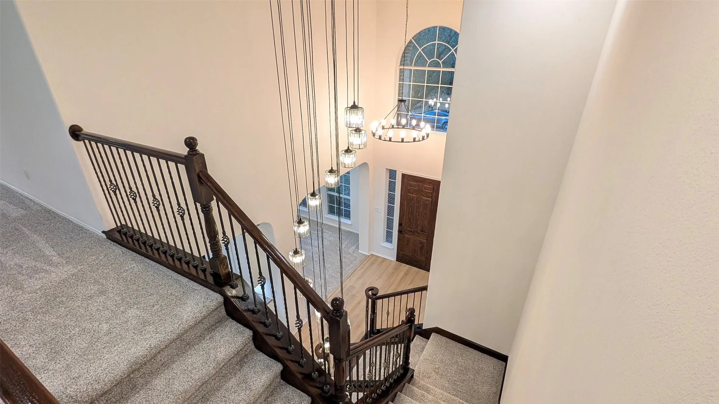 Stairway featuring carpet floors, a high ceiling, and hanging lights