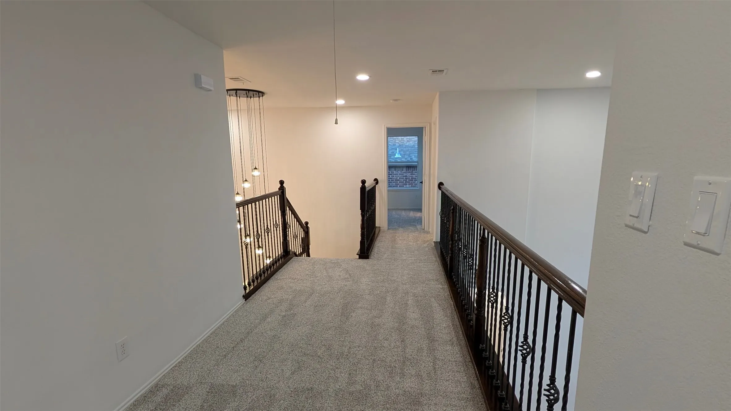 Hall with an upstairs landing, carpet, and recessed lighting