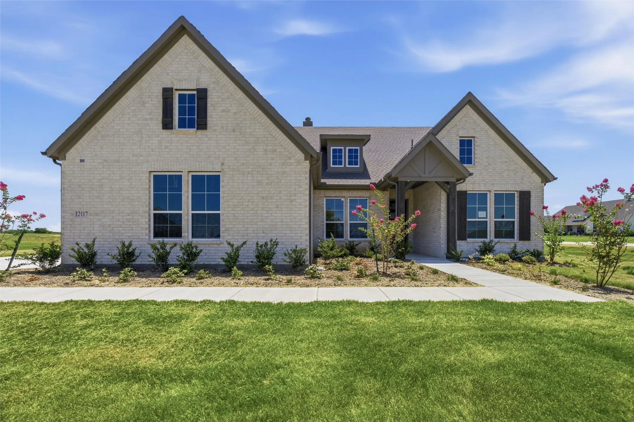 Cream brick exterior with dark trim and shutters