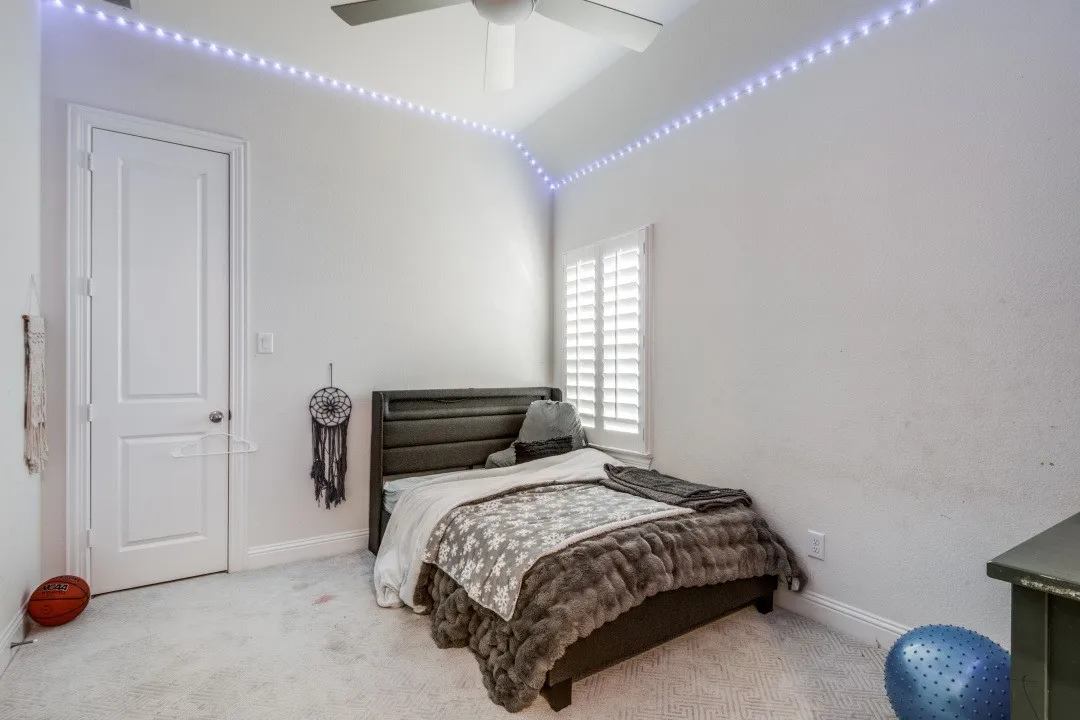 Carpeted bedroom with baseboards and a ceiling fan