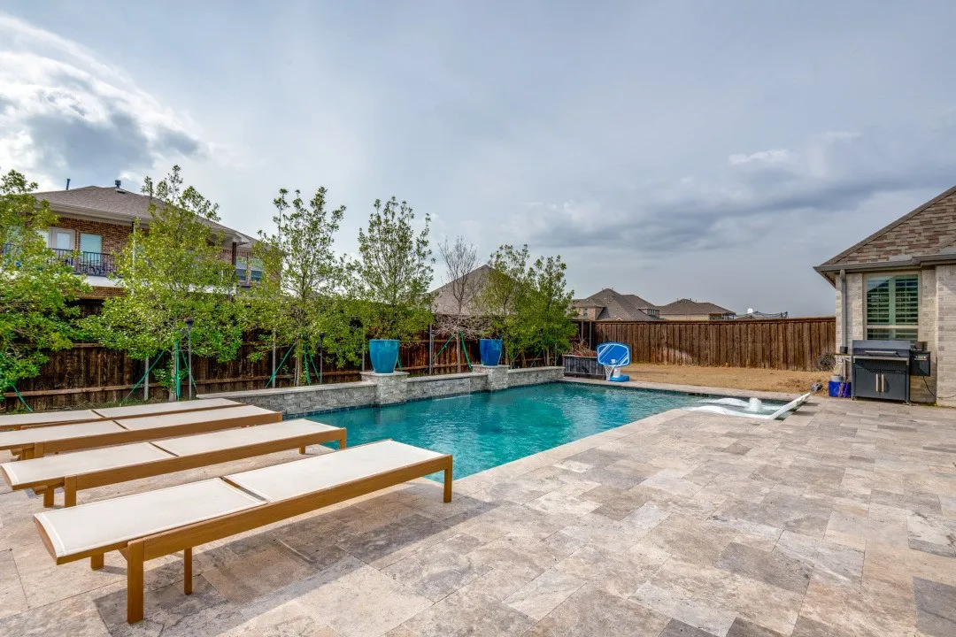 View of swimming pool featuring a fenced backyard, patio surround, and grilling area
