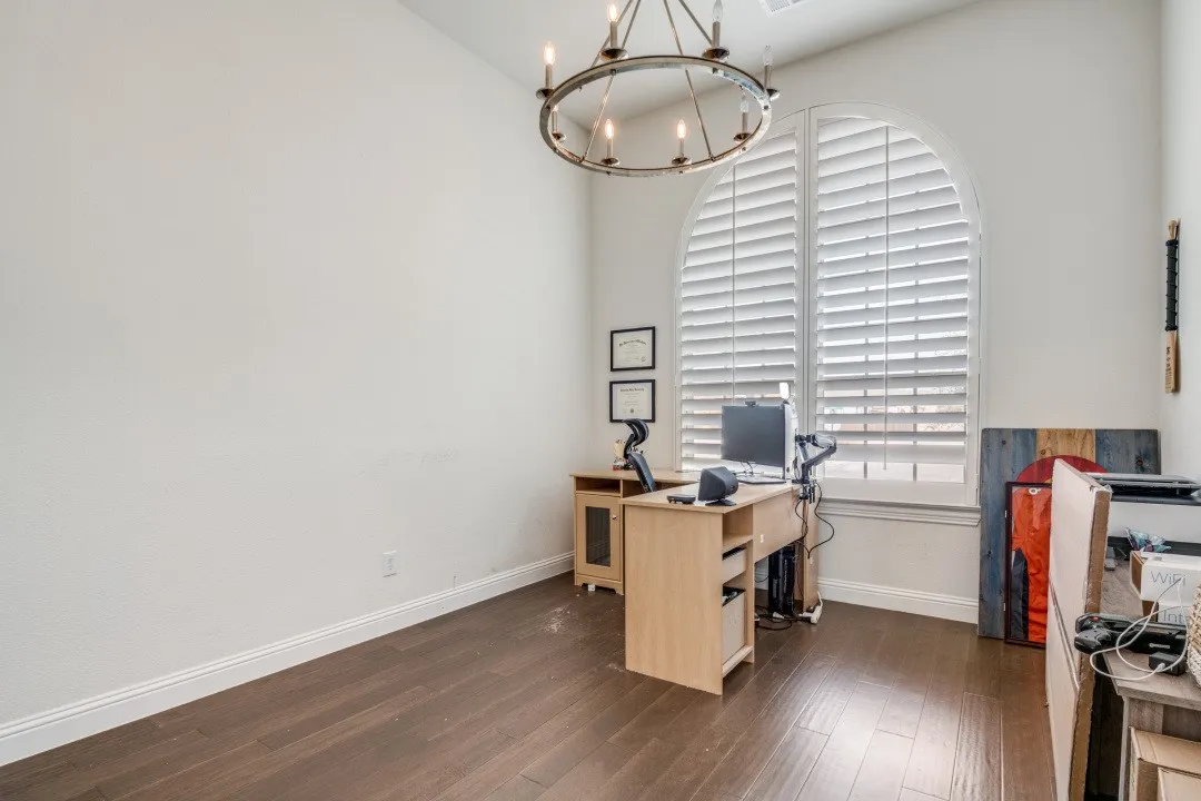 Office space with suspended lighting and dark wood-style flooring