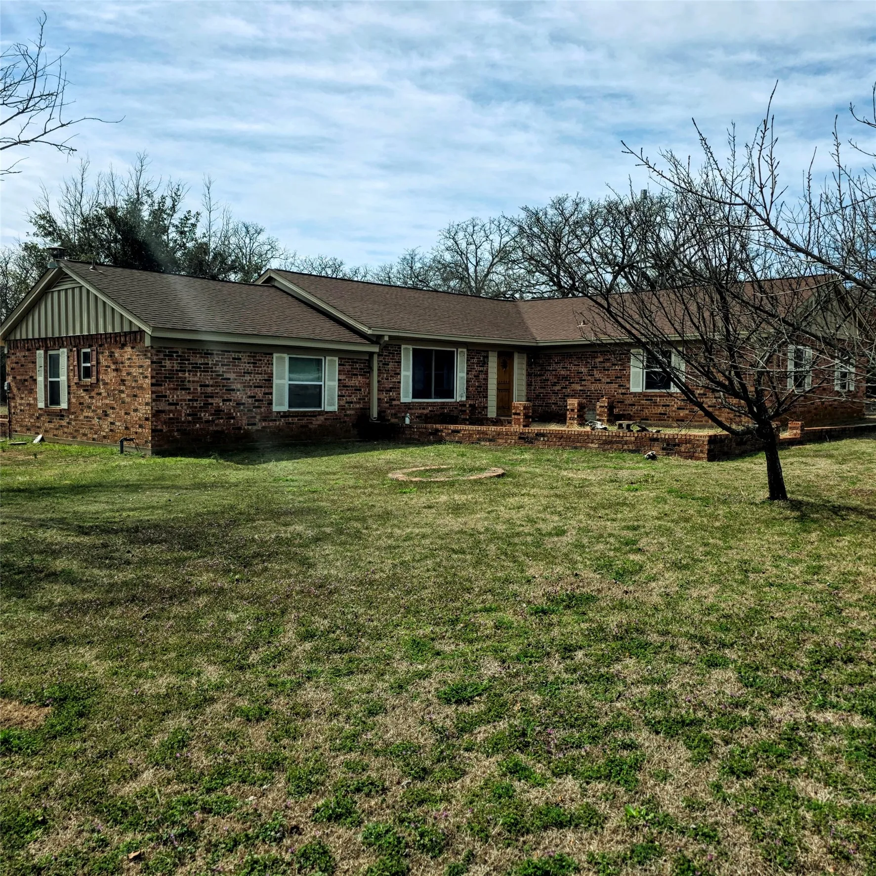 Ranch-style house with a front lawn, brick siding, and board and batten siding