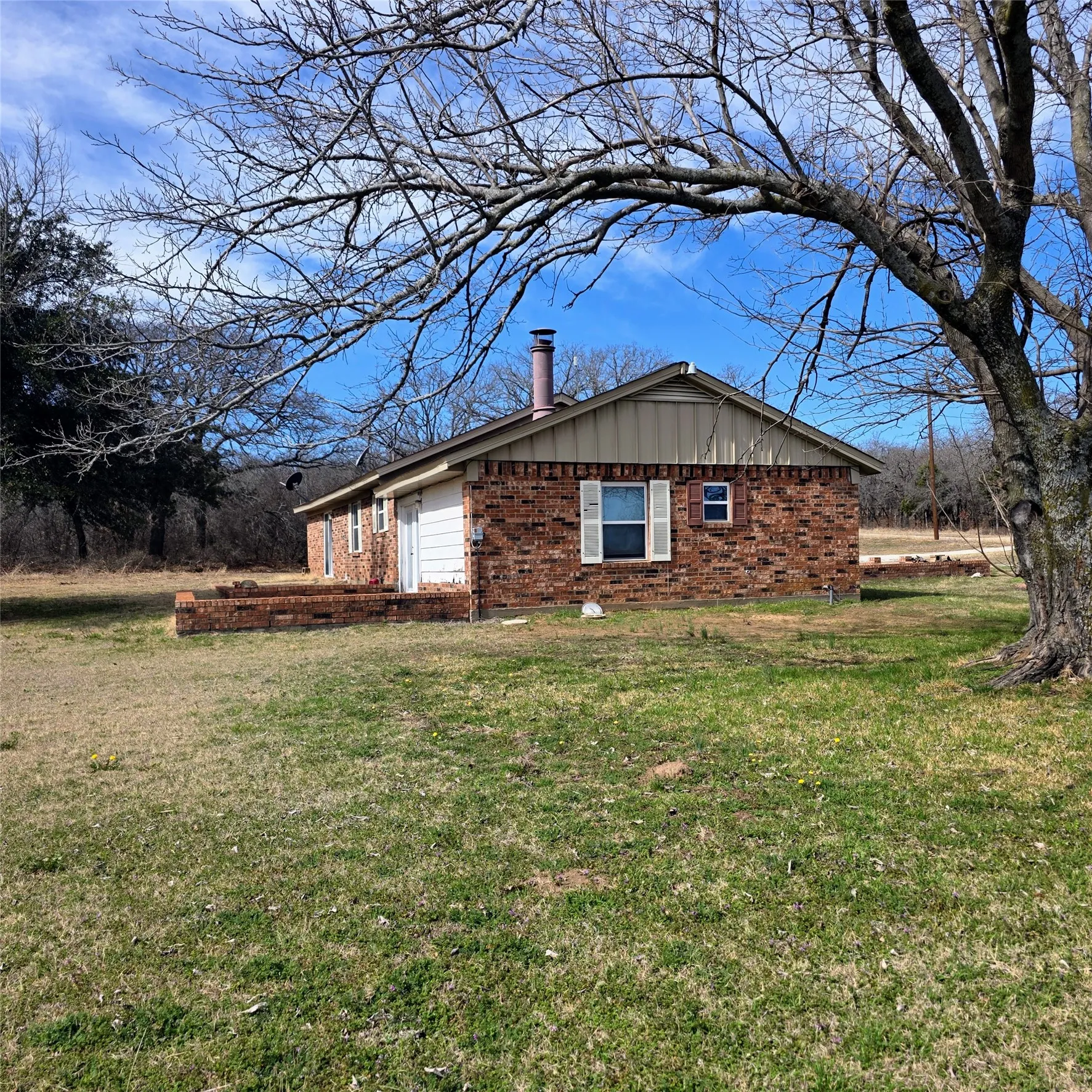 View of home's exterior featuring brick siding and a yard