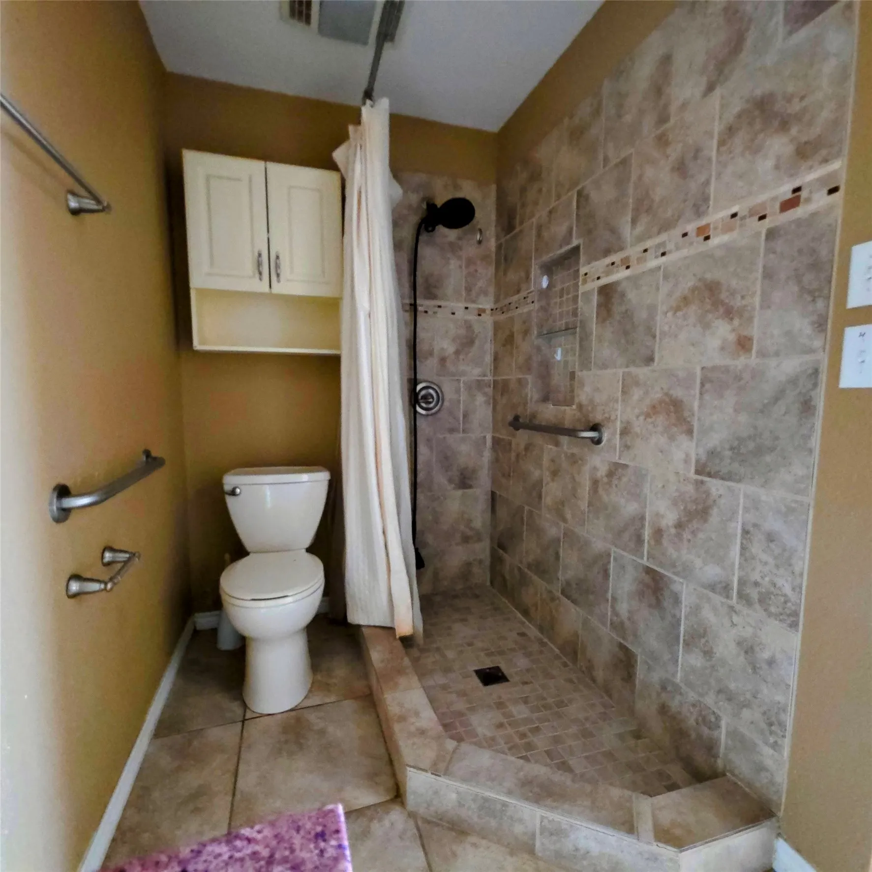 Full bath featuring a tile shower and light tile patterned floors