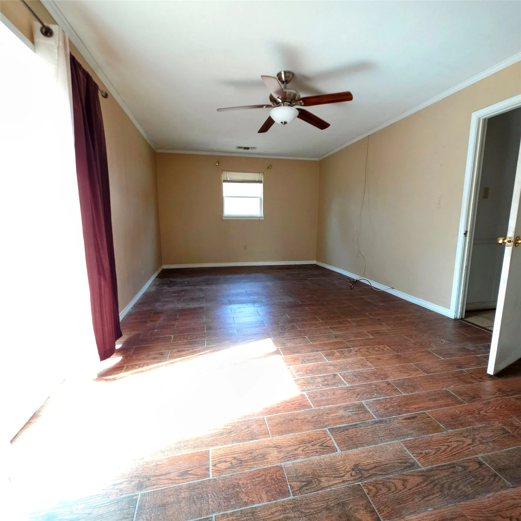 Spare room with a ceiling fan, crown molding, and wood tiled floors