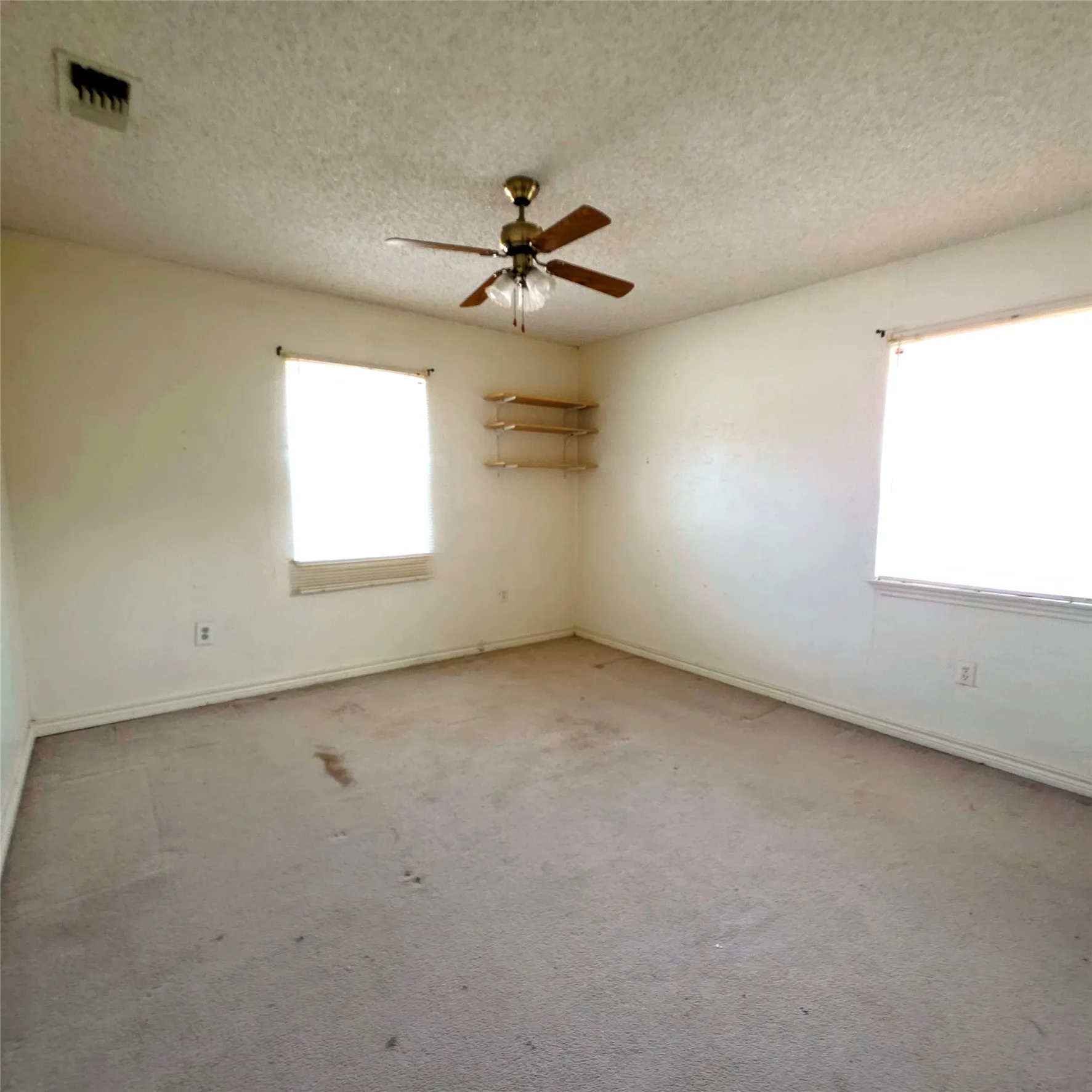  room with a textured ceiling, carpet flooring, and ceiling fan