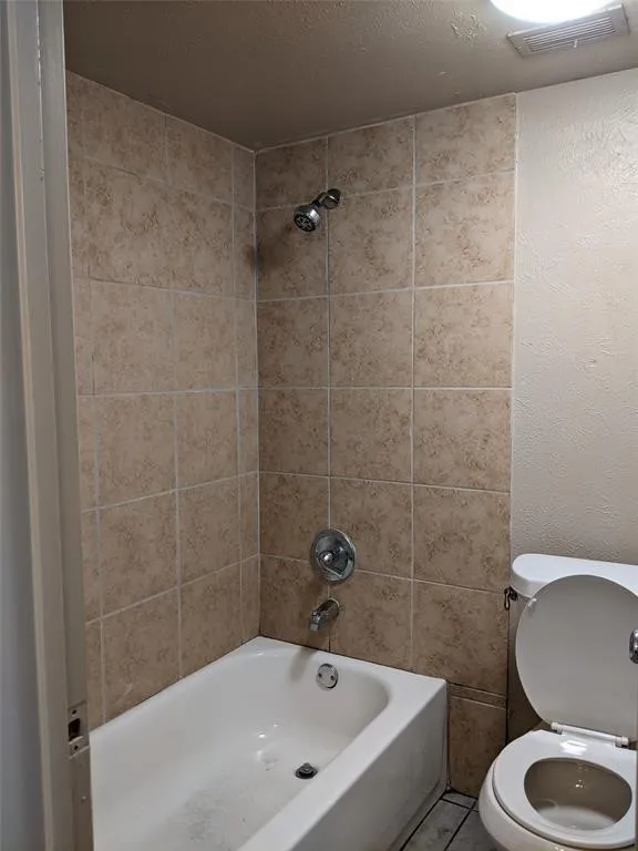 Bathroom featuring shower / washtub combination and a textured ceiling