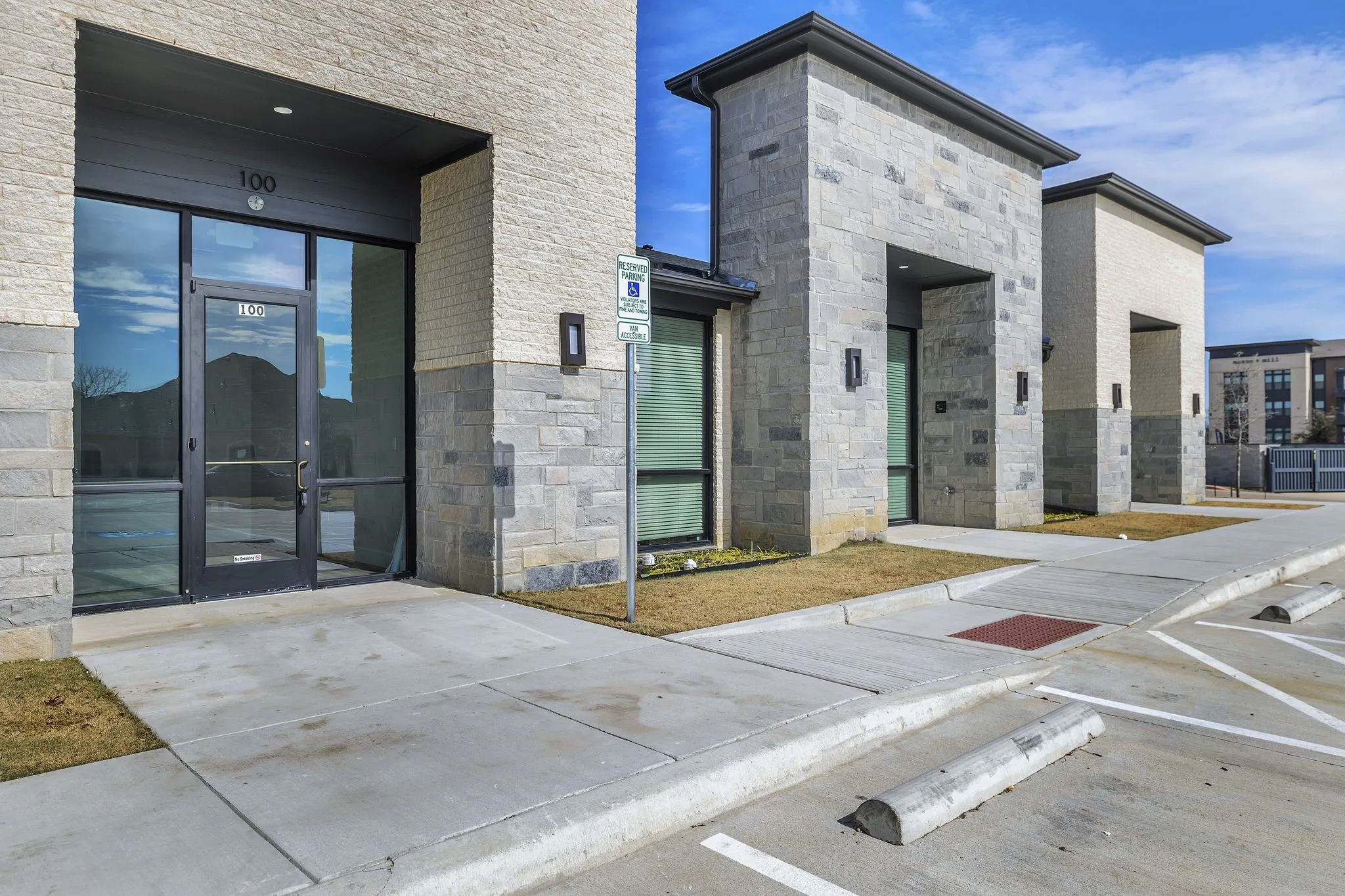 View of exterior entry featuring stone siding and uncovered parking