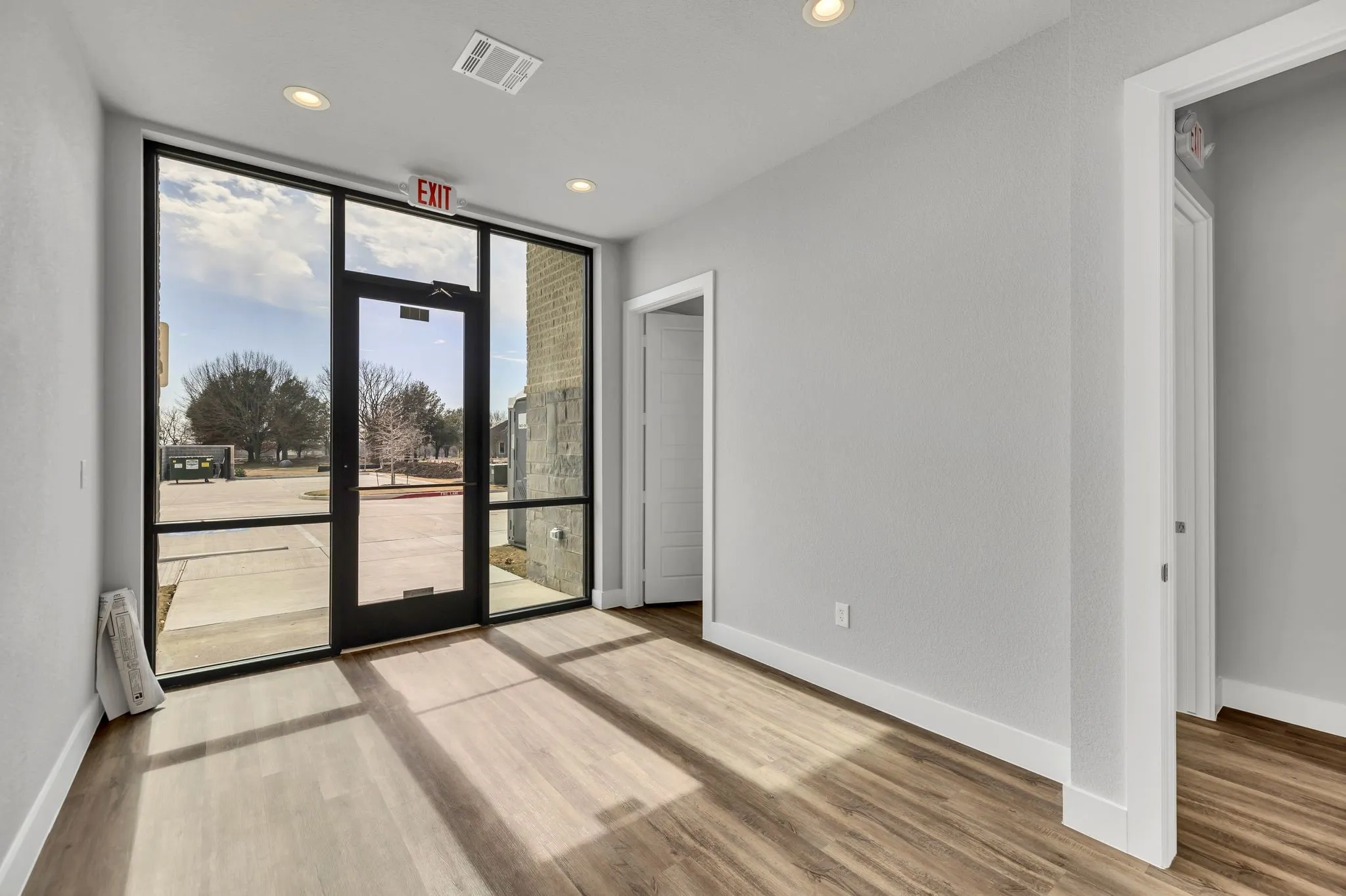 Empty room with expansive windows, recessed lighting, and light wood finished floors