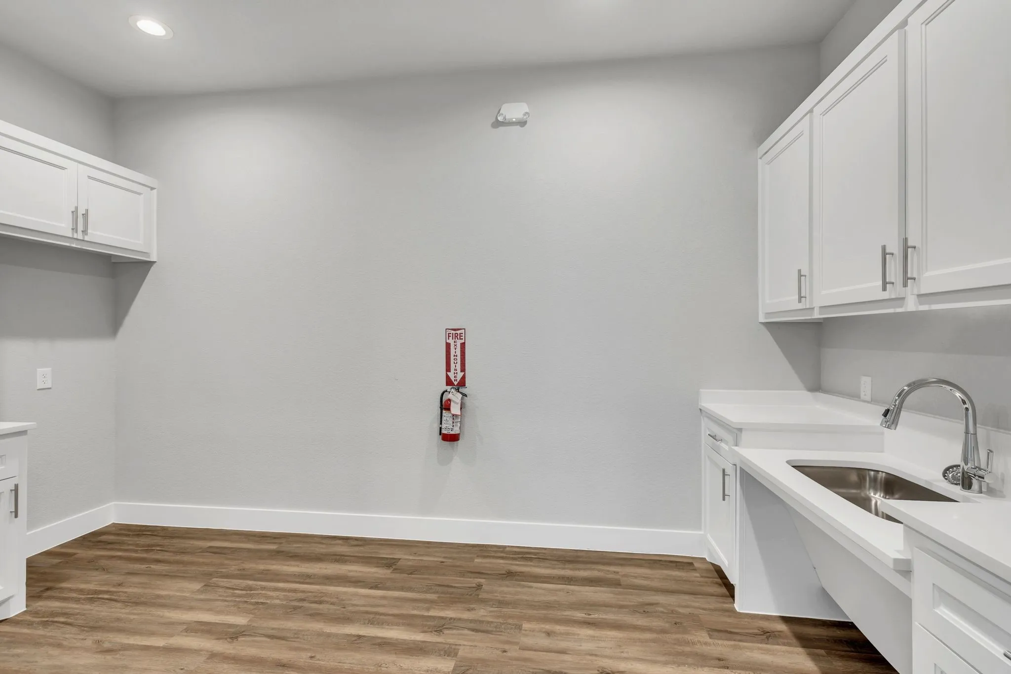 Laundry room with cabinet space, light wood-style floors, and recessed lighting