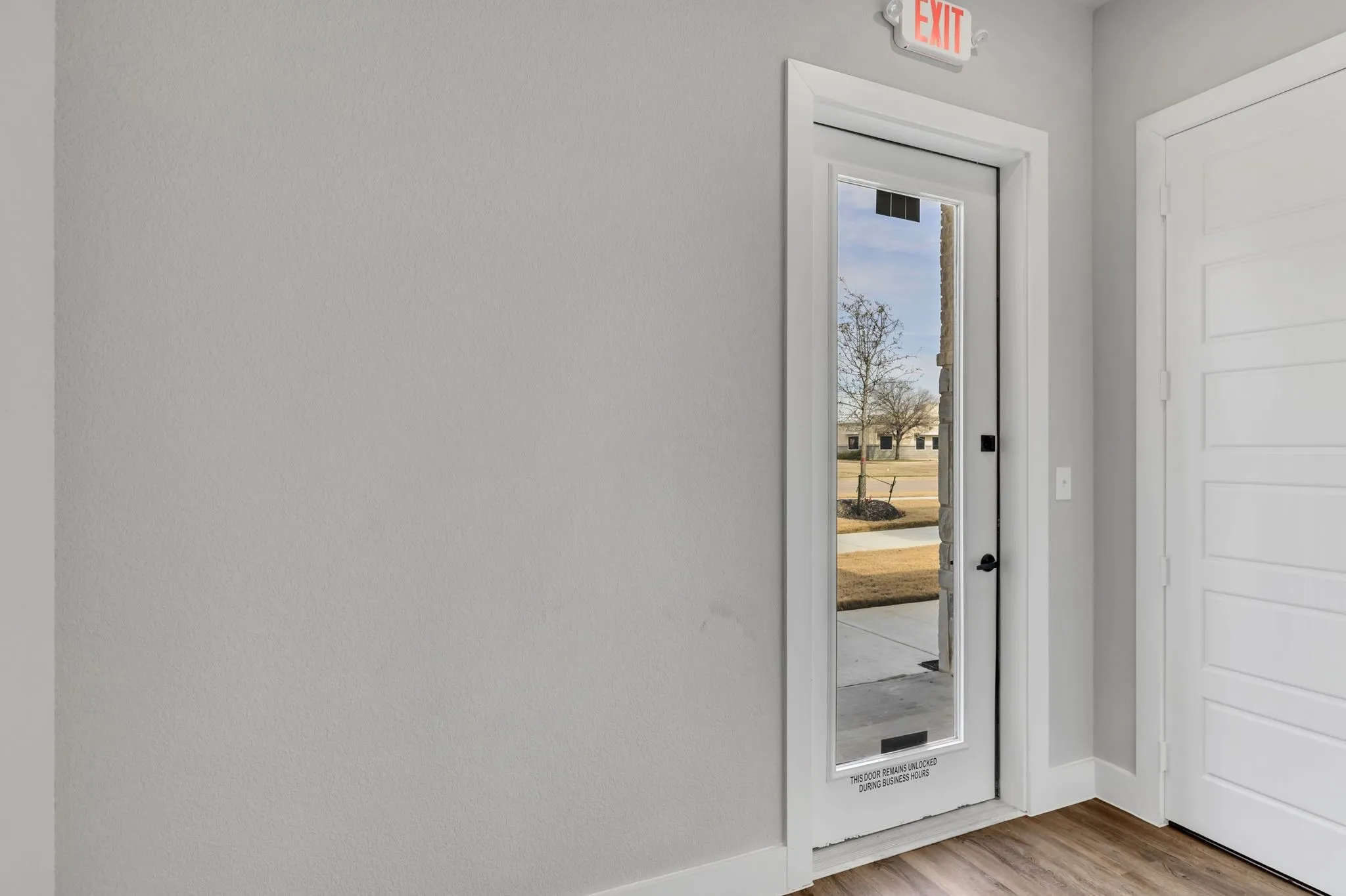 Doorway with baseboards and wood finished floors