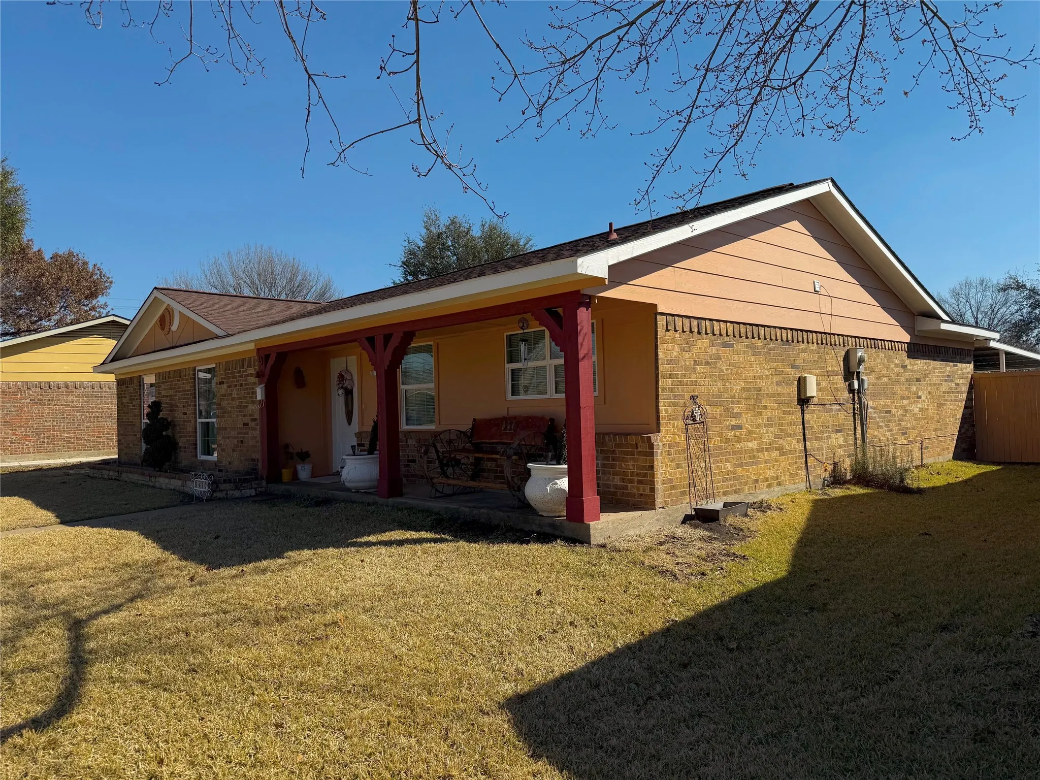 Rear view of house with brick siding and covered porch