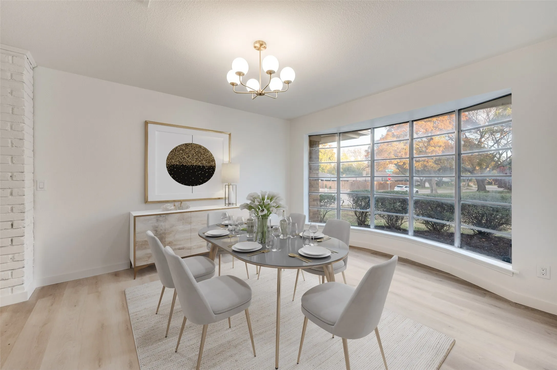 The spacious dining room is complete with designer lighting and expansive views of the front yard.