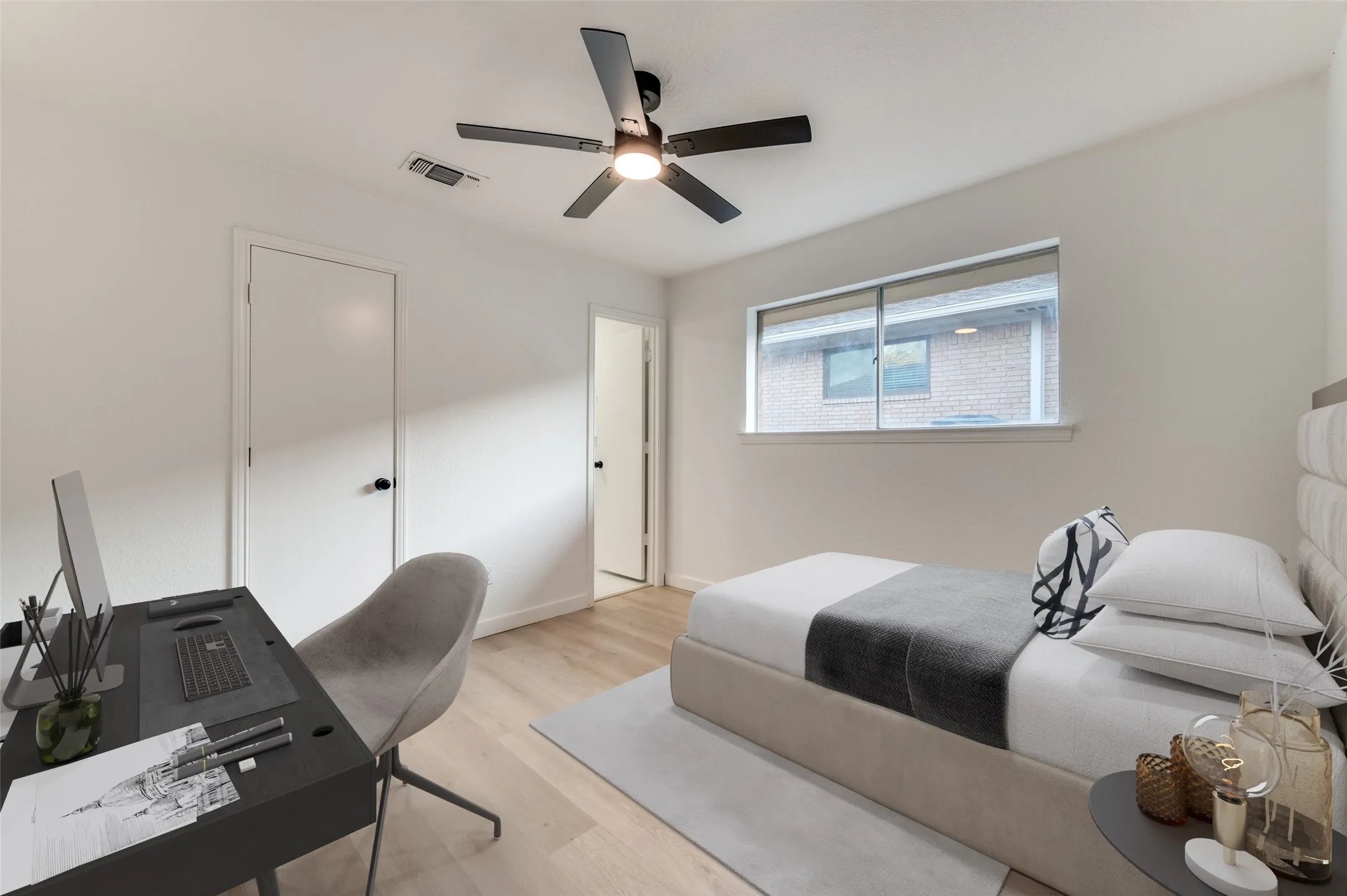 Comfortable secondary bedroom with modern fan and direct access to updated guest bath.