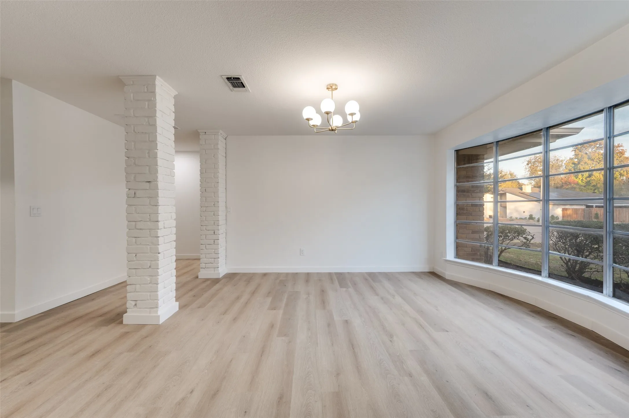Architectural brick columns add character while maintaining an open-concept connection between dining and living areas, with easy access to the kitchen.