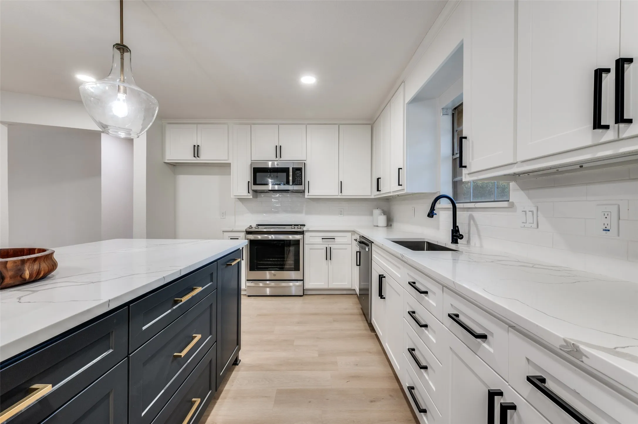 The new stainless steel appliance suite features a convection oven, large sink, and 28-bottle wine fridge.