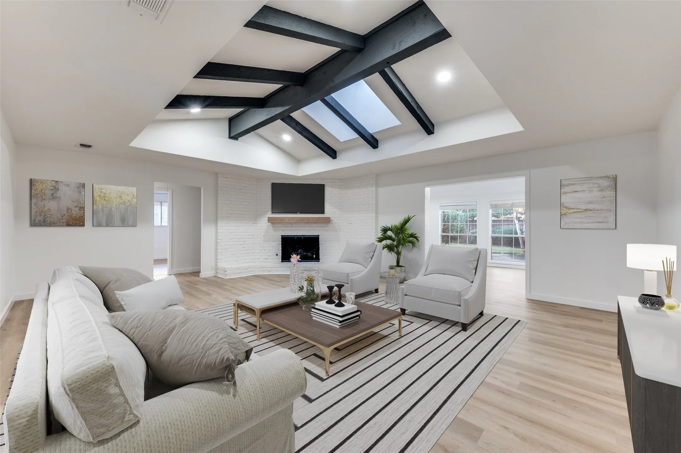 Vaulted living room featuring exposed beams, skylight, and a painted brick fireplace with custom white oak mantel.