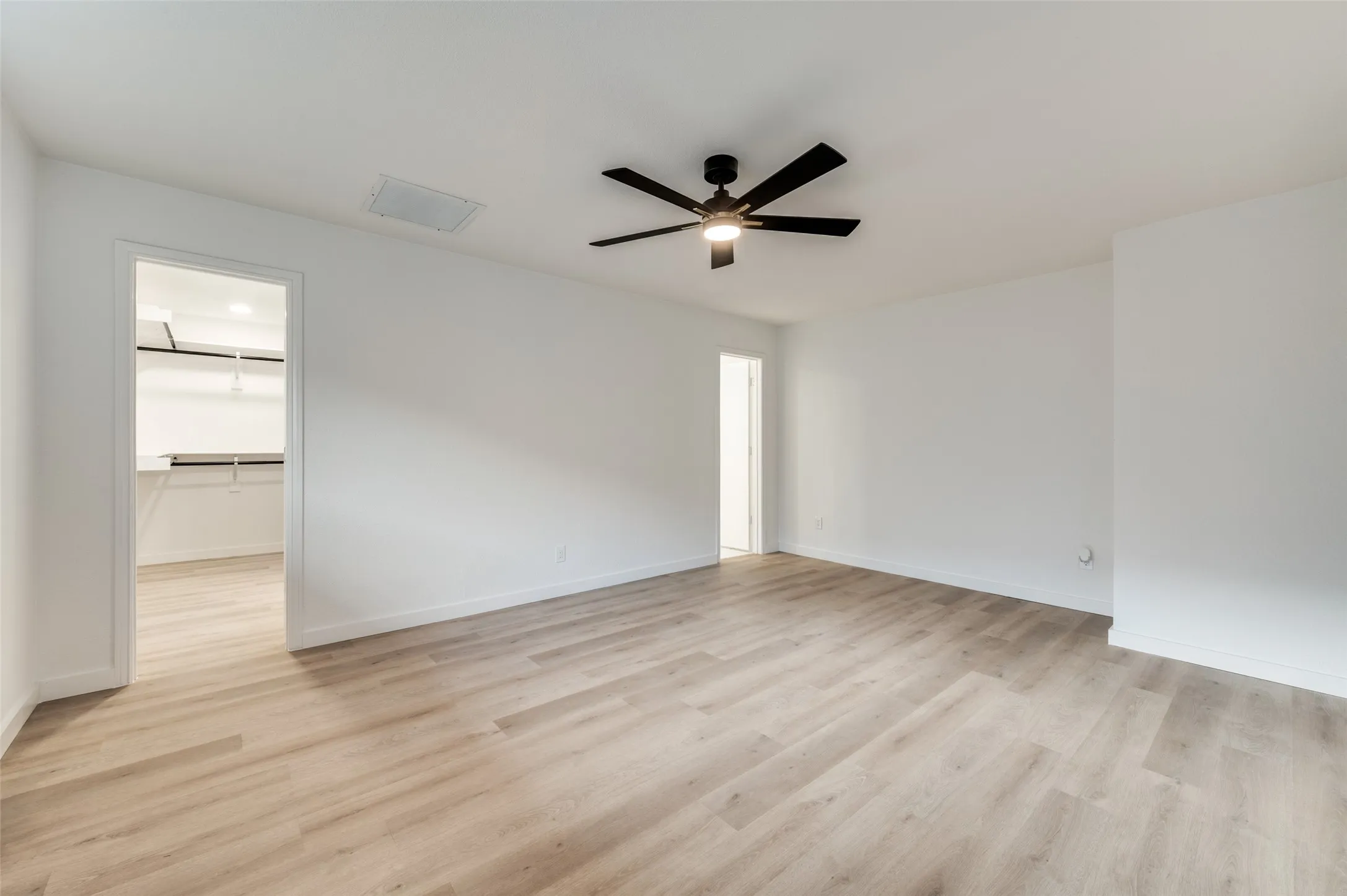 The primary bedroom is generously sized with room for a sitting area and continues with the modern, clean lines found throughout the house, but with extra luxe gold details.