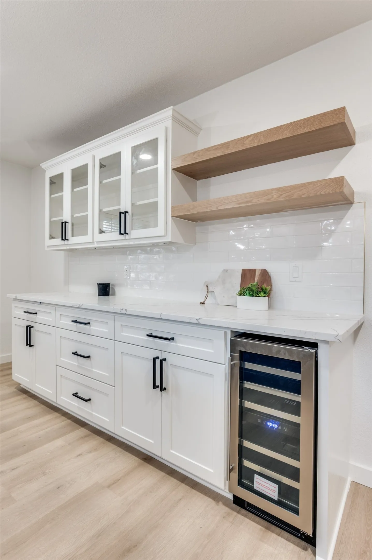Entertain in style by putting your best glassware and bottles on display in your glass-front cabinetry and on your custom white oak open shelving.