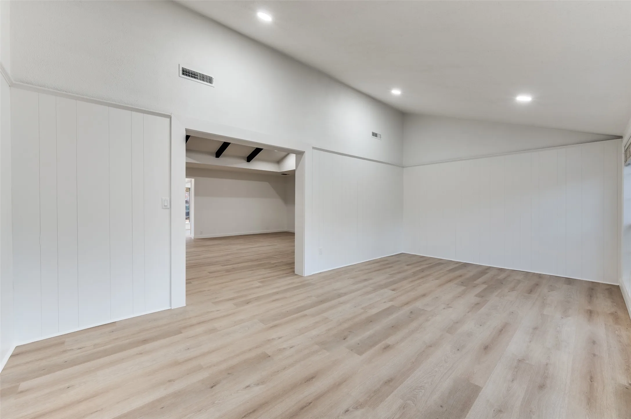 Vaulted bonus lounge with shiplap detail and direct backyard access—ideal as a media room, fitness studio, creative space, or relaxed secondary living area.