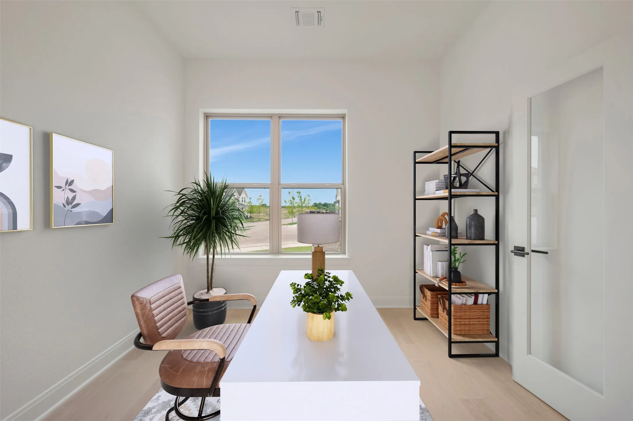 Bright room featuring a large window, light-toned wood-finish flooring, white walls, and a modern interior door with frosted glass panel