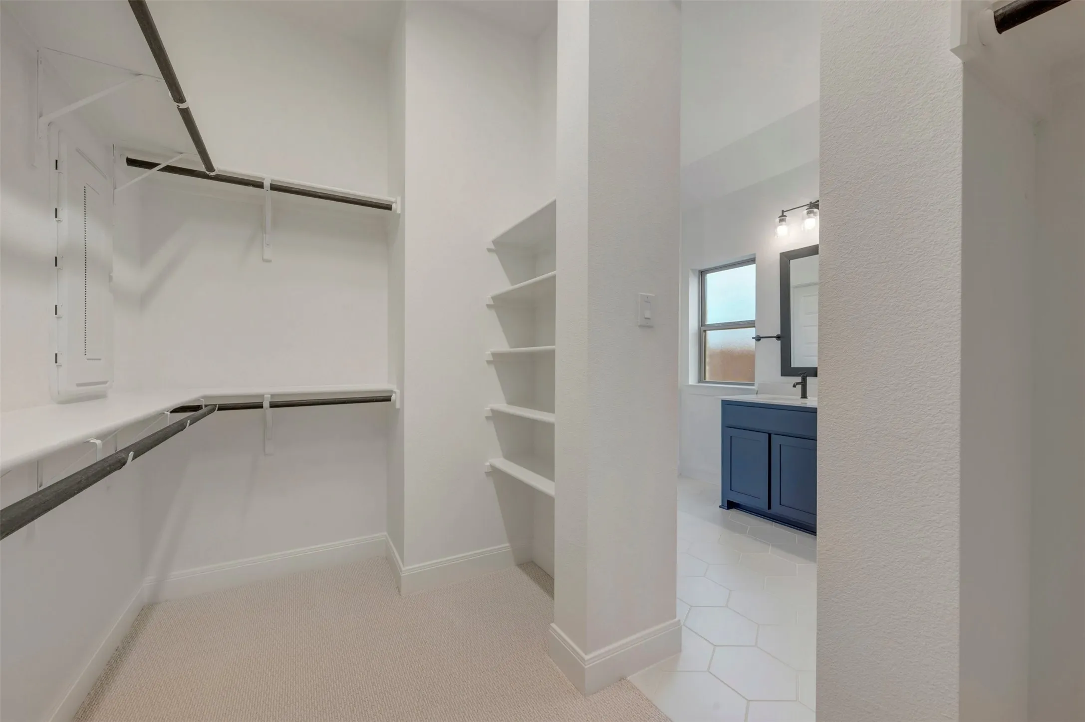 Walk-in closet featuring built-in shelving, hanging rods, and carpet flooring