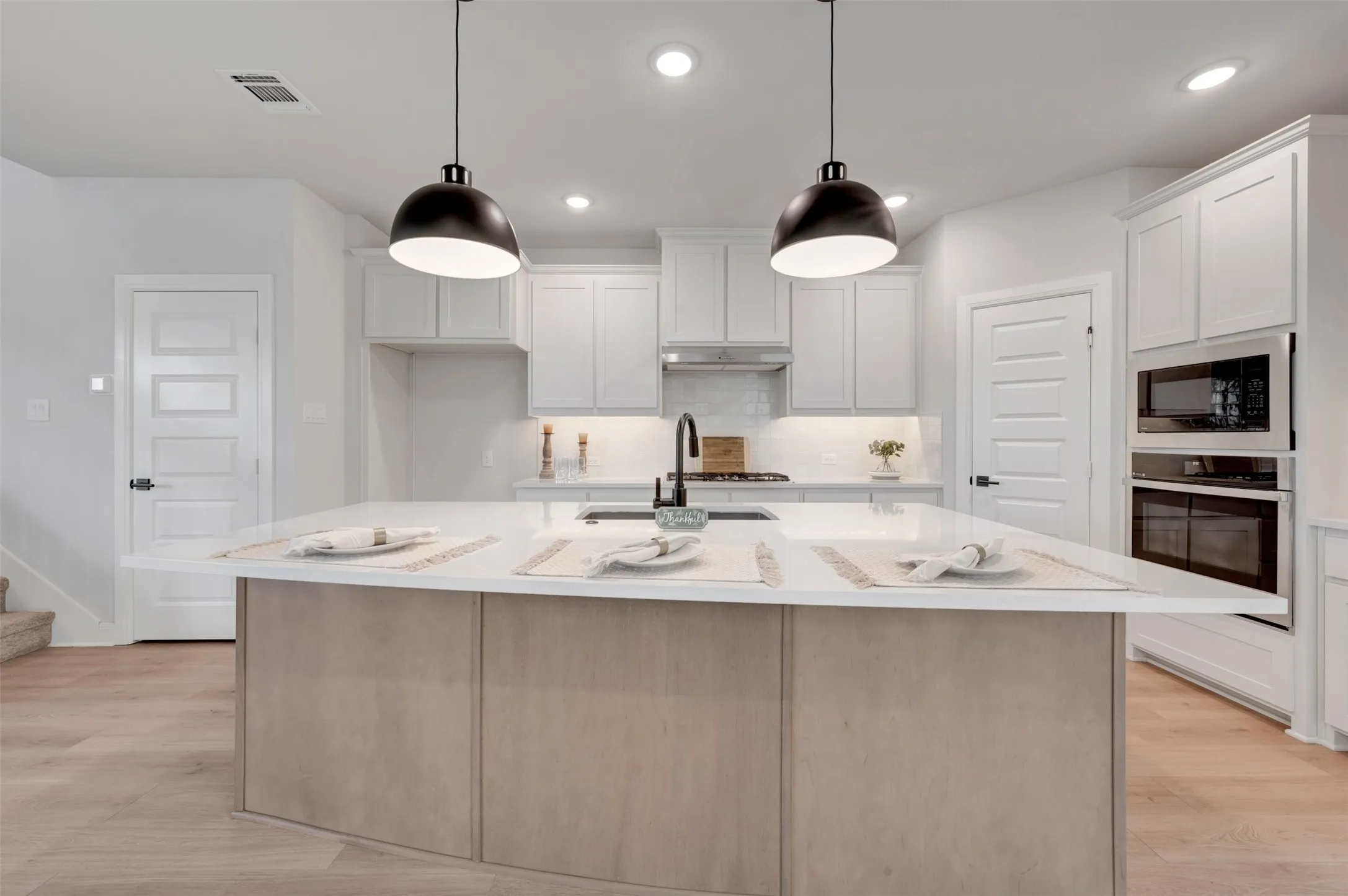 Kitchen featuring a spacious island with a light wood-finish base and light-toned countertop