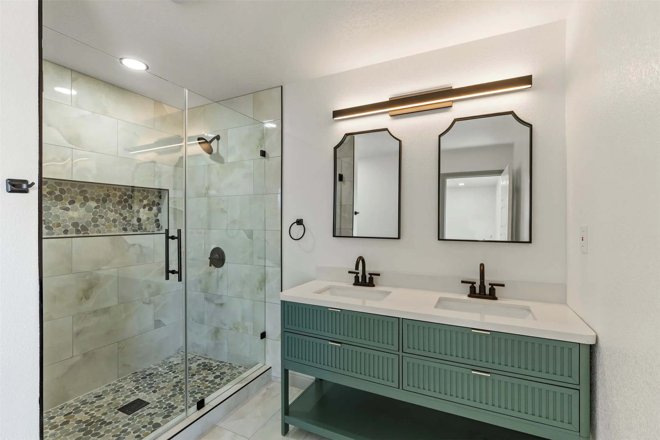 Bathroom with double vanity, a shower stall, and recessed lighting