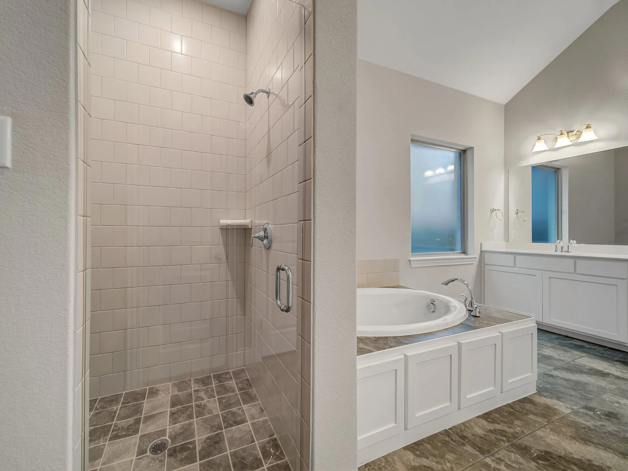 Bathroom featuring a stall shower, a garden tub, and vanity