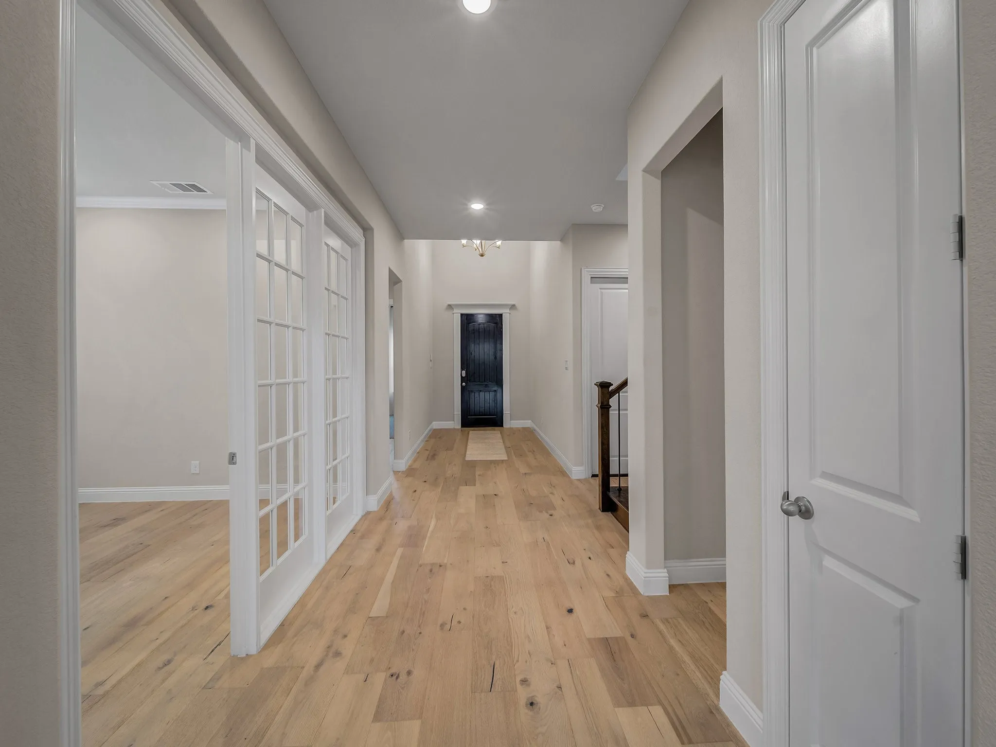 Hallway with light wood finished floors and recessed lighting