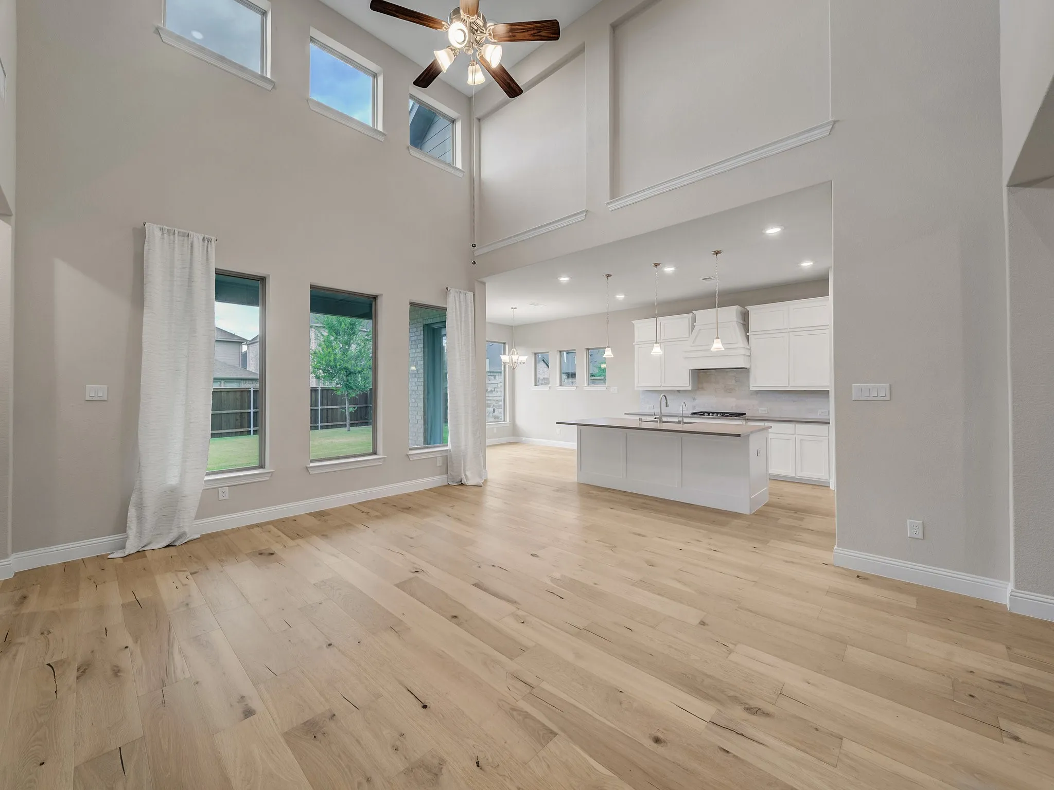 Unfurnished living room with light wood finished floors and ceiling fan