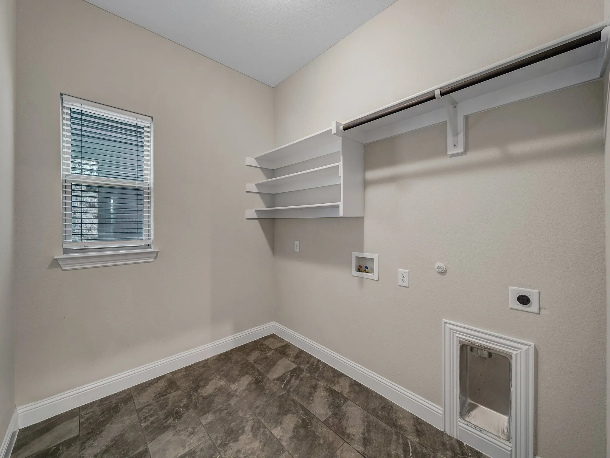 Laundry area with electric dryer hookup, hookup for a gas dryer, and washer hookup