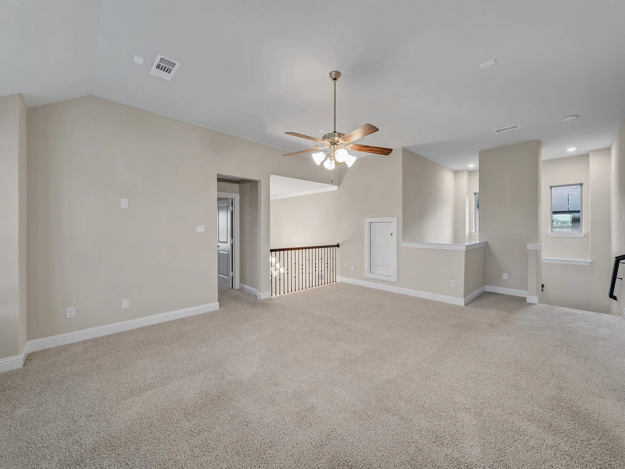Empty room featuring light colored carpet and a ceiling fan