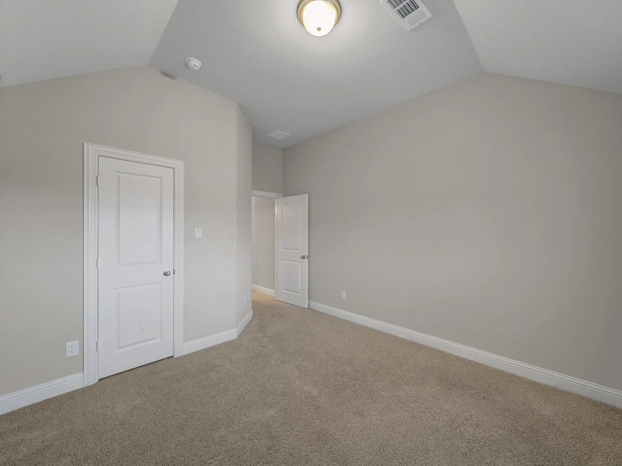Unfurnished bedroom featuring lofted ceiling and carpet