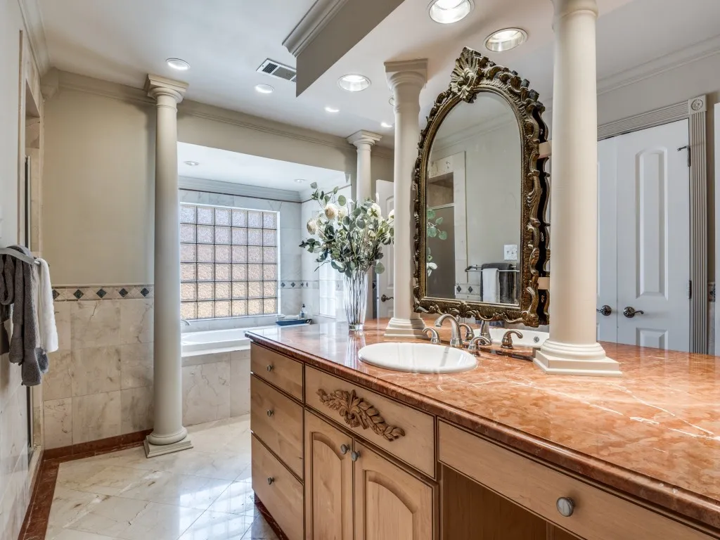 Primary bath is huge, with each side offering a generous walk-in closet and its own vanity