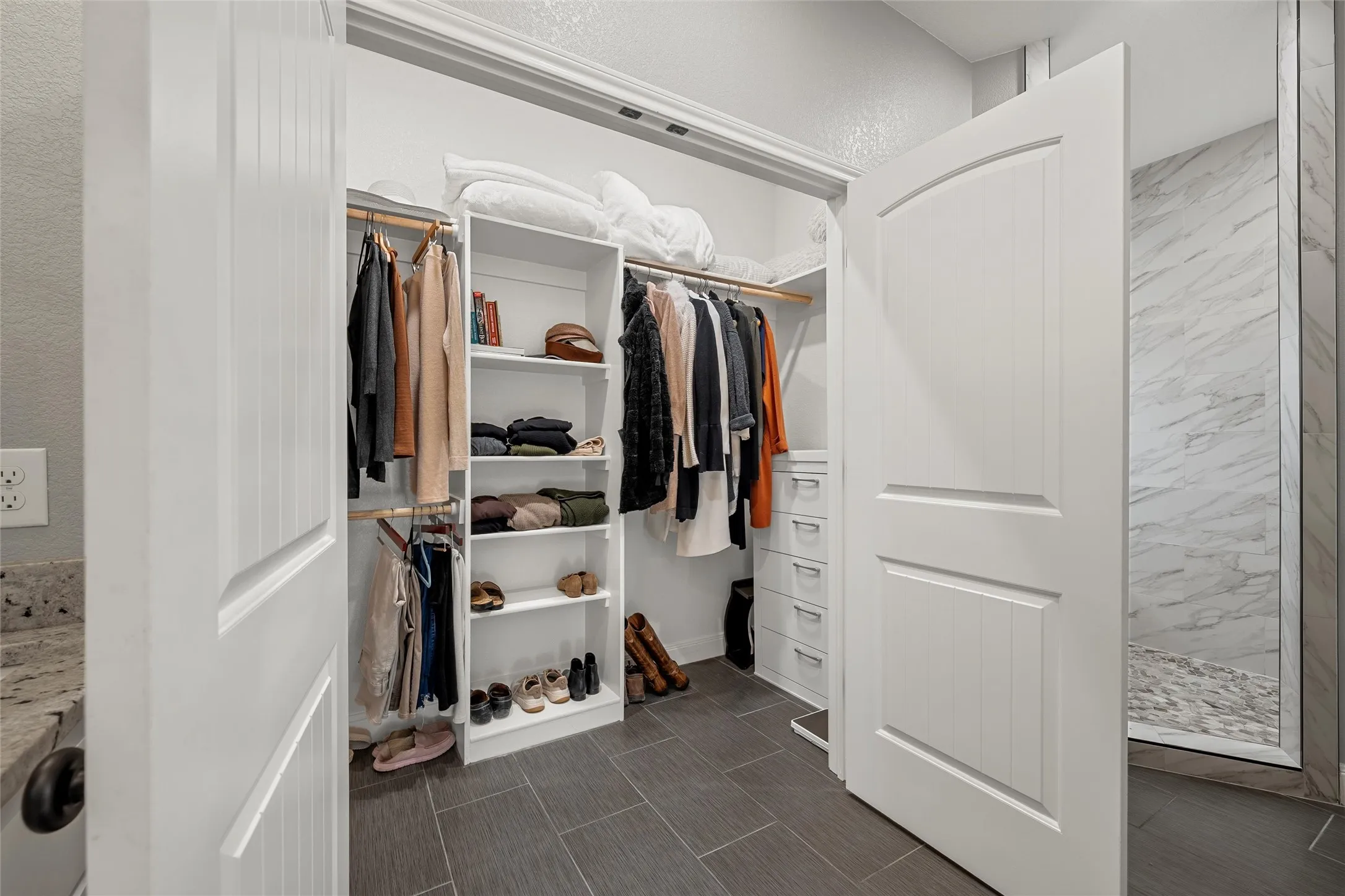 Spa-style primary bathroom with double-sink granite vanity, custom white cabinetry, black matte hardware, dual pendant lighting, separate shower, and secluded soaking tub — 117 Lost Oaks Drive, Waco TX 76705.