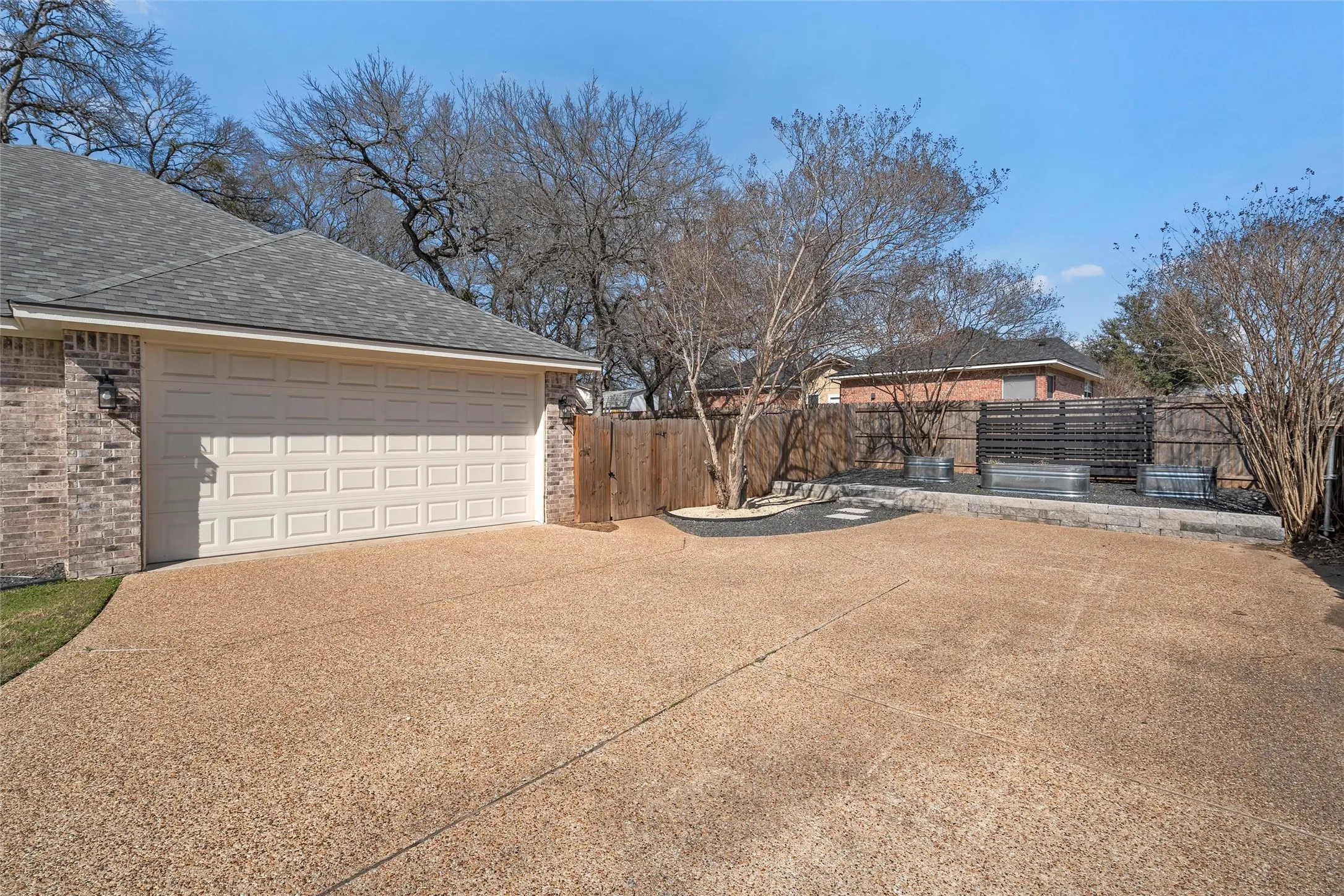 all-brick home with extended concrete motor court, for parking recreational vehiciles, no HOA, attached 2-car garage entry from the side, raised bed garden area, space for basketball goal — 117 Lost Oaks Drive, Waco TX 76705.