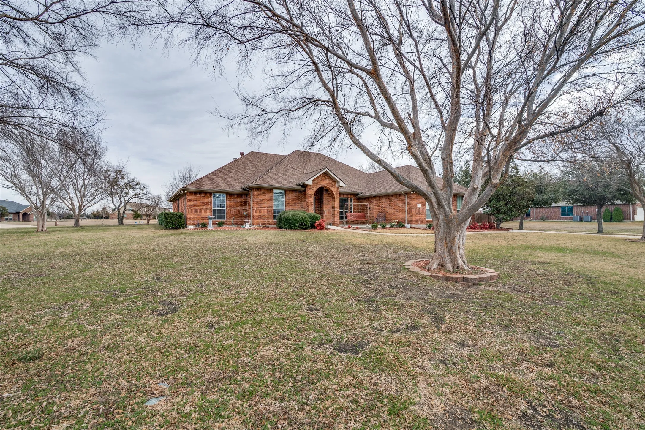 Single story home with a front lawn, brick siding, and a shingled roof