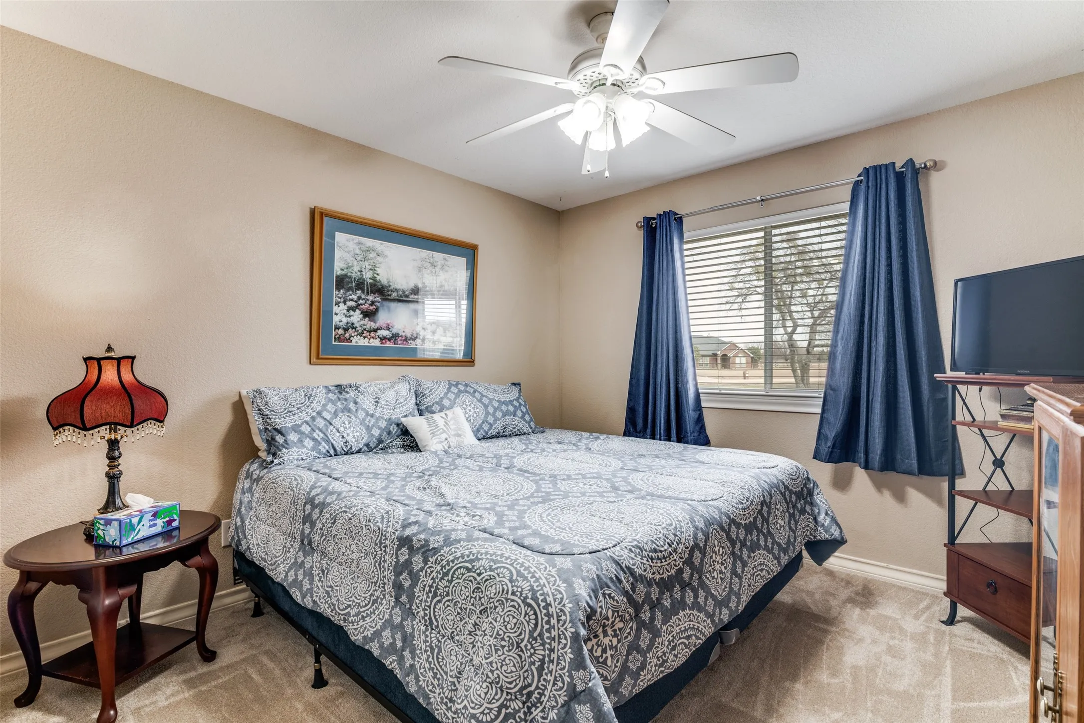 Carpeted bedroom featuring baseboards and a ceiling fan