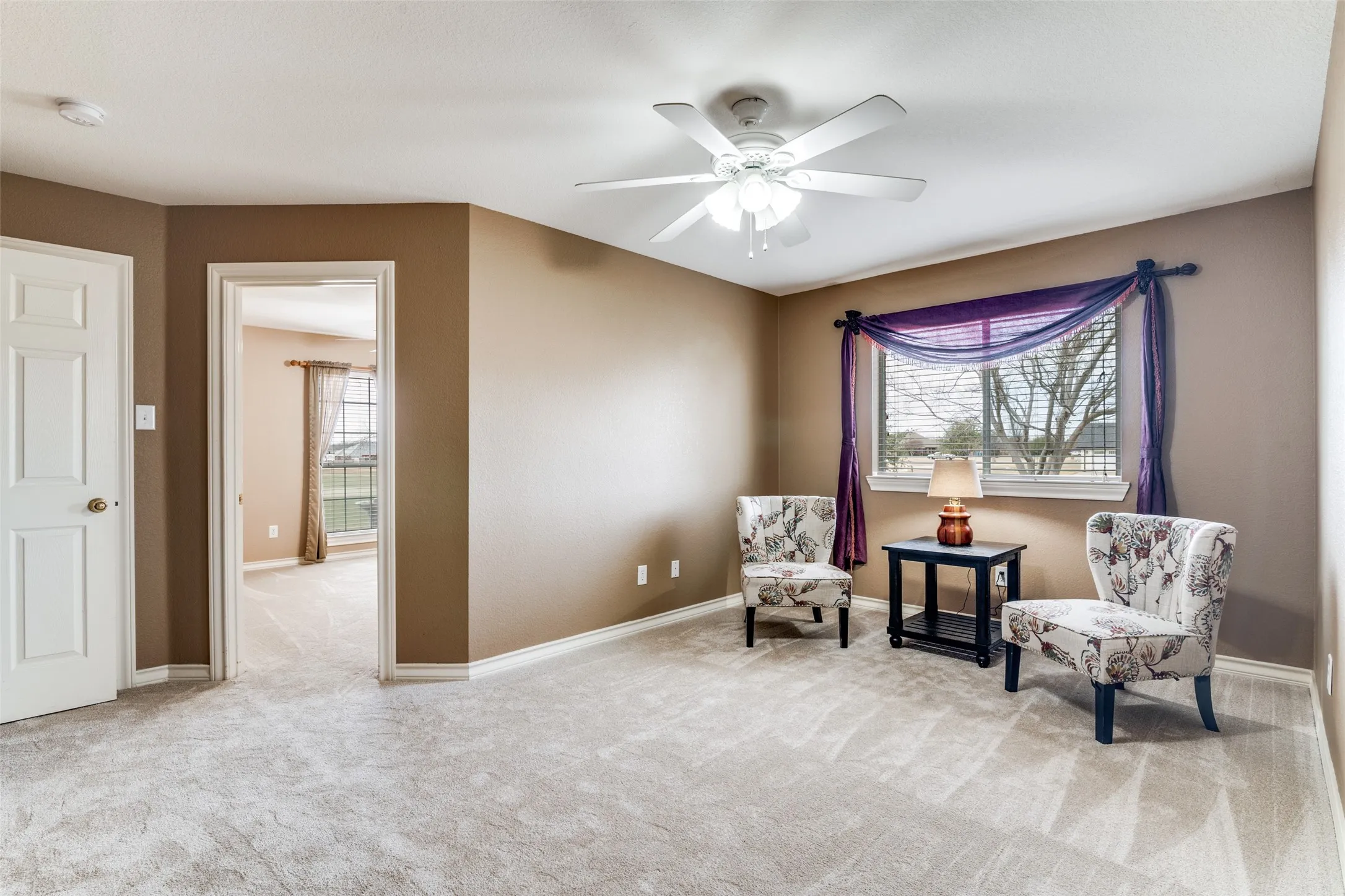 Game/Sitting Room with a ceiling fan and light carpet
