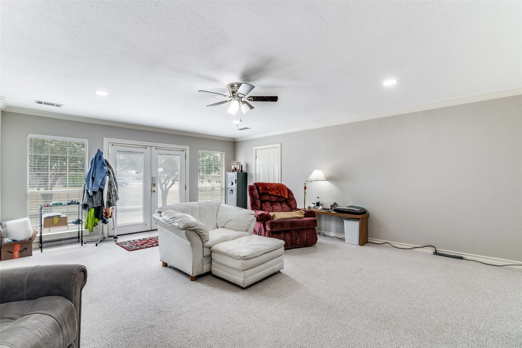 Carpeted living room with french doors, ceiling fan, crown molding, and recessed lighting