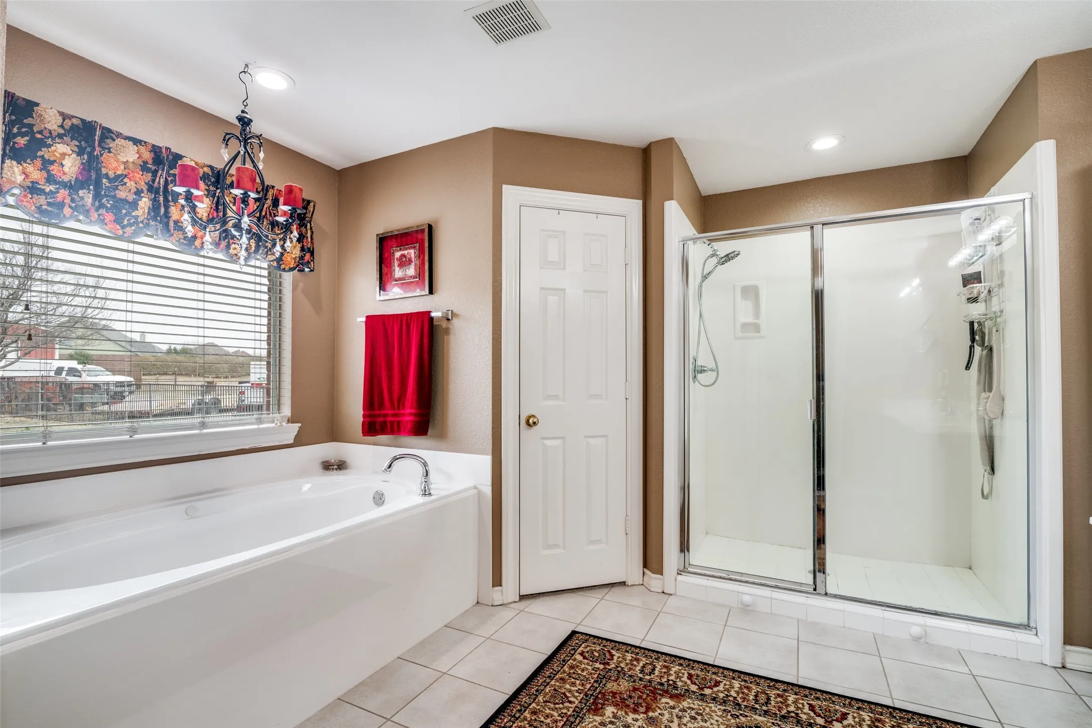 Full bath with a shower stall, a bath, and light tile patterned floors