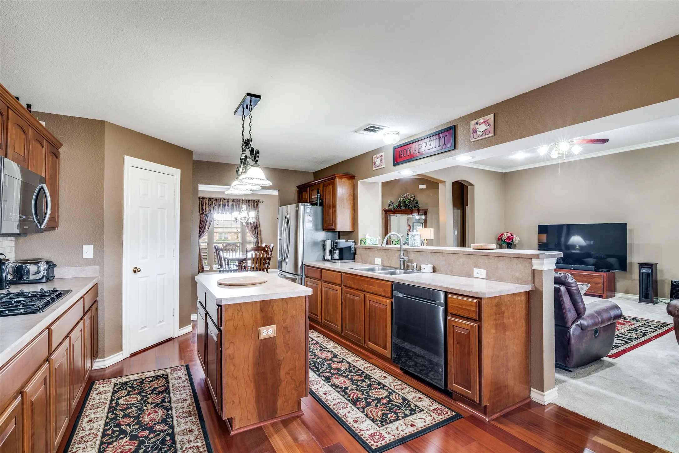 Kitchen featuring open floor plan,  wood finish cabinets, and light countertops