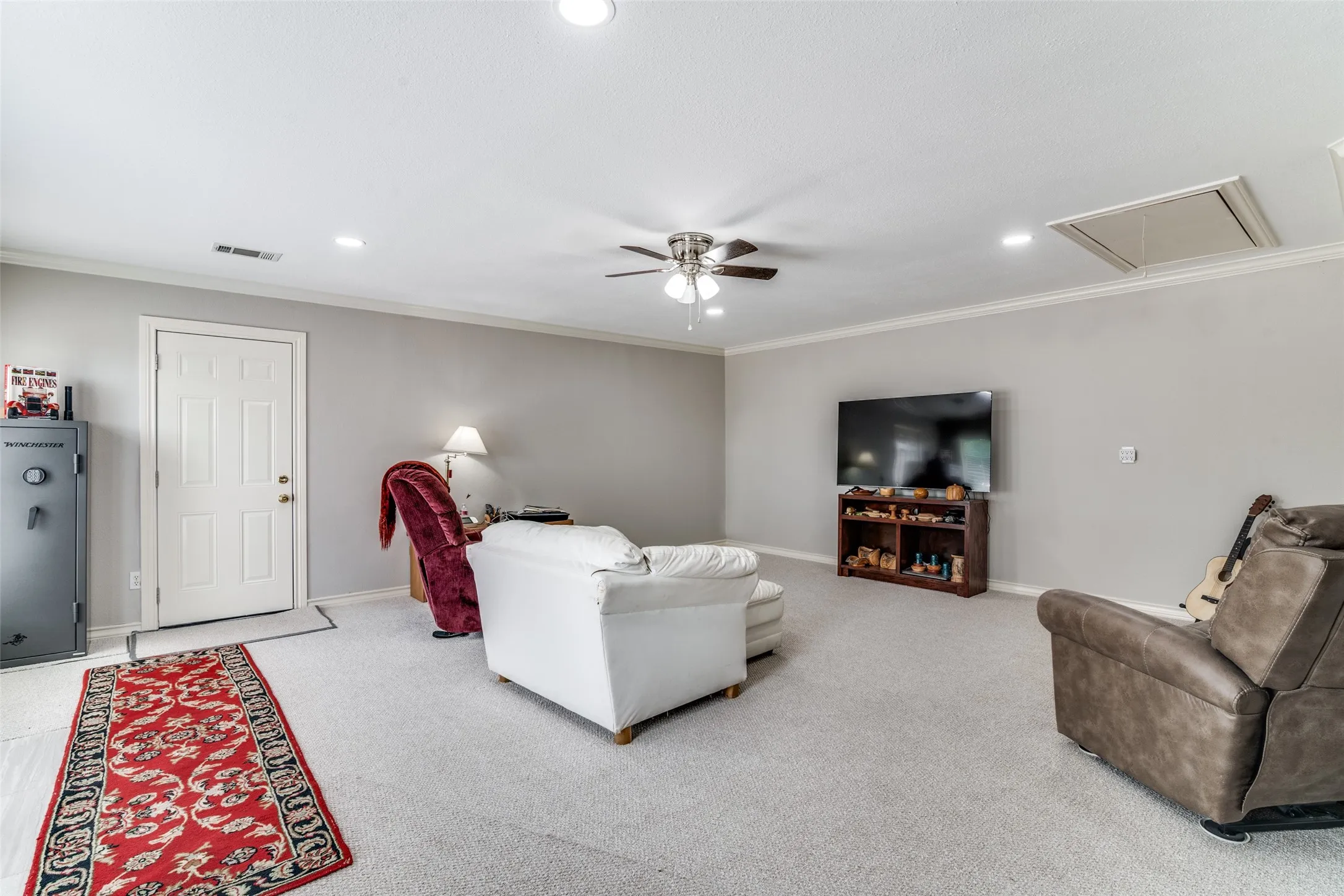 Carpeted living area with ornamental molding, a ceiling fan, and recessed lighting