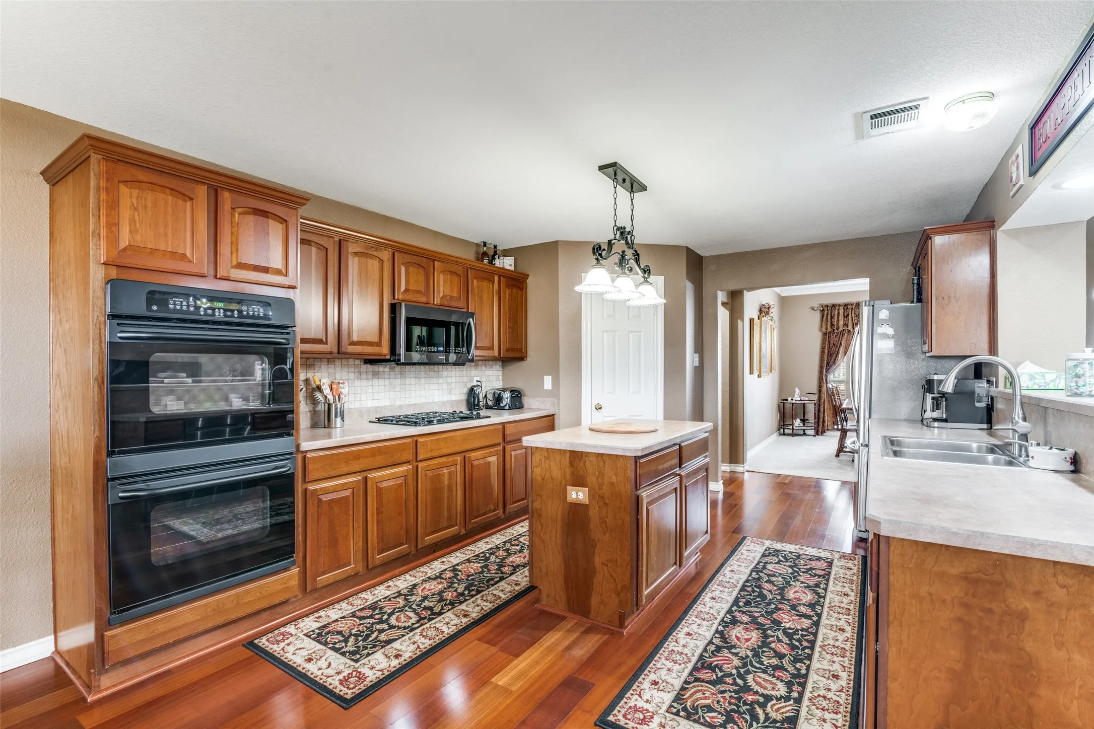 Kitchen with wood finish cabinetry, light countertops, and pendant lighting