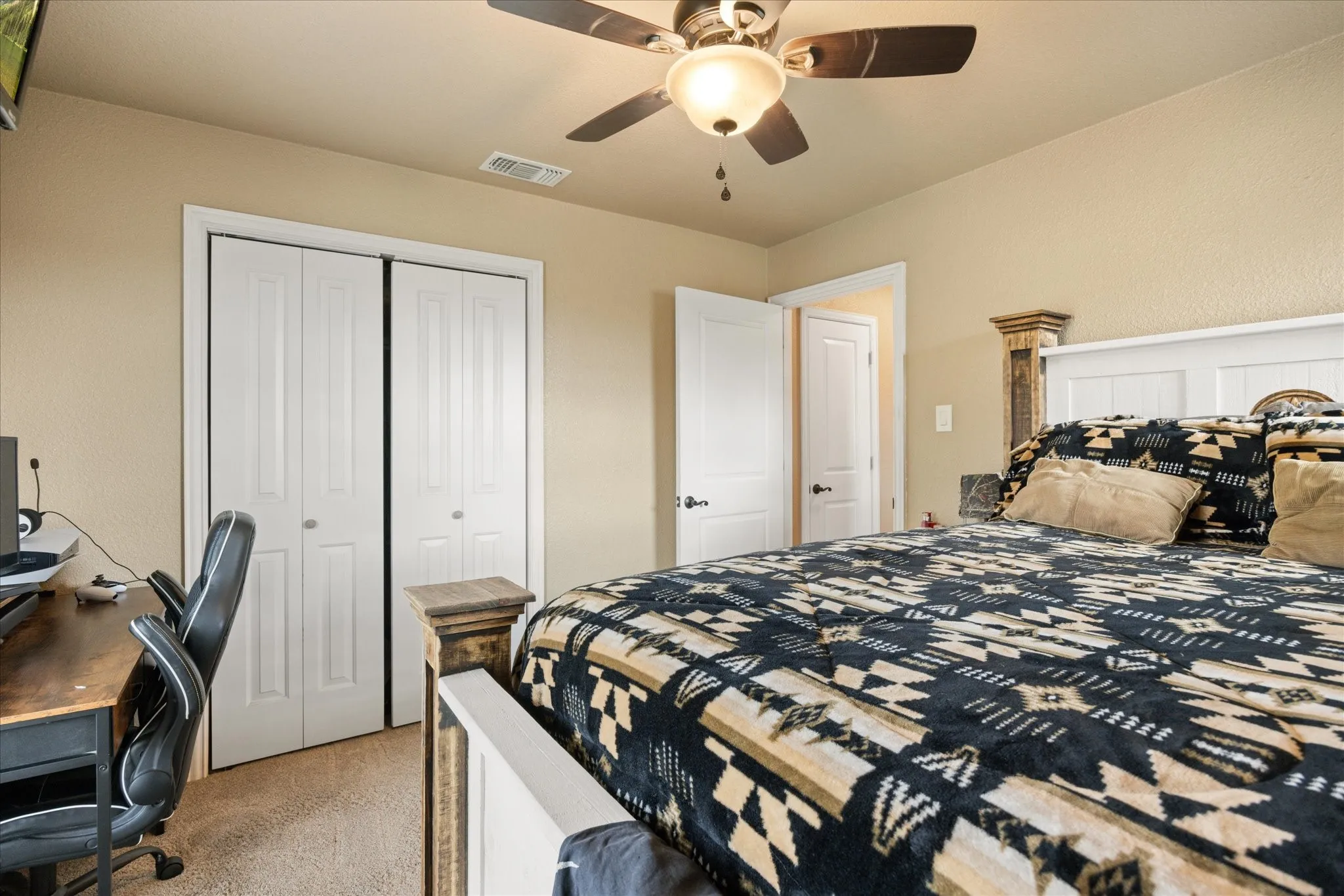 Bedroom featuring a closet, light carpet, and ceiling fan
