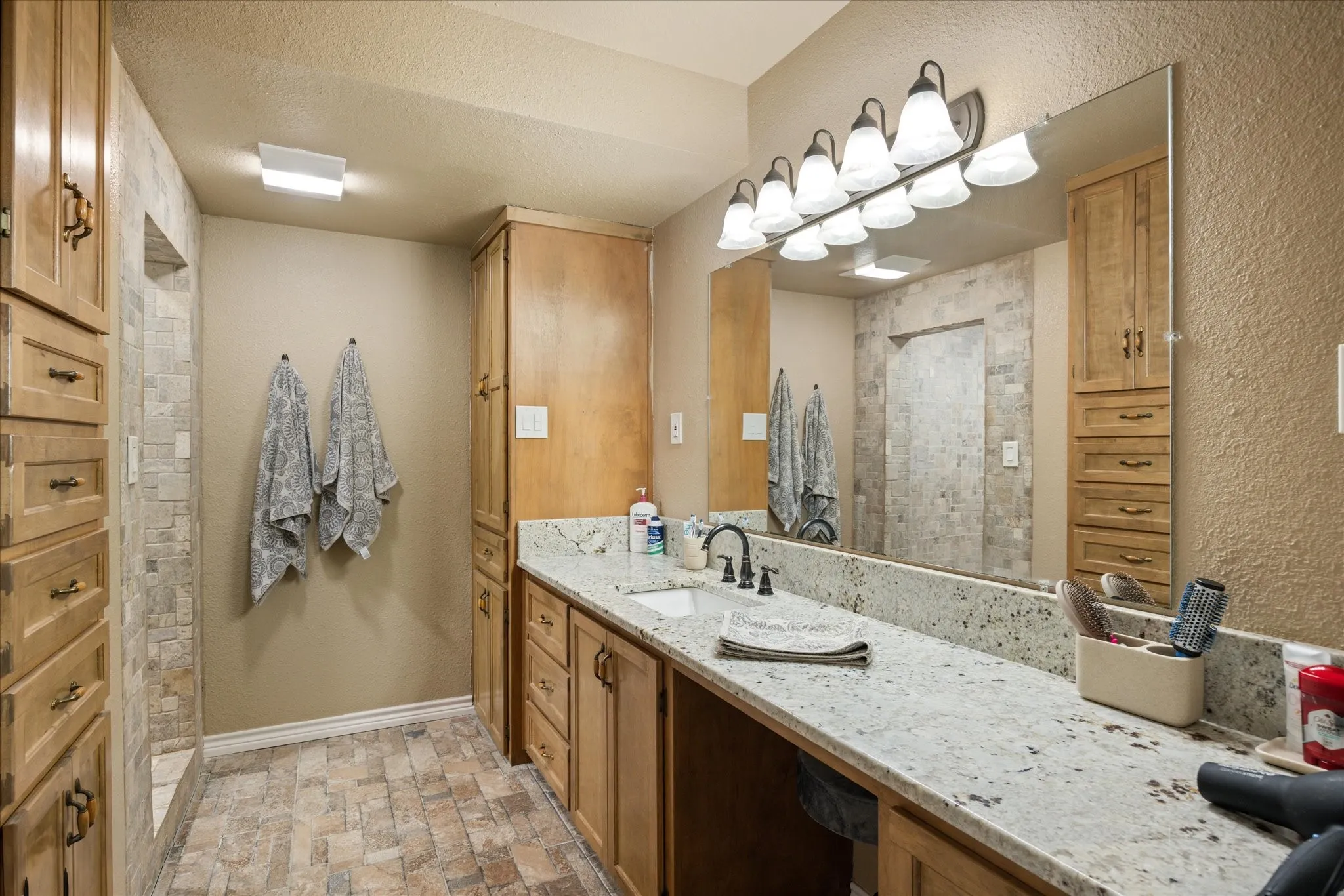 Bathroom with vanity, a textured ceiling, and a shower