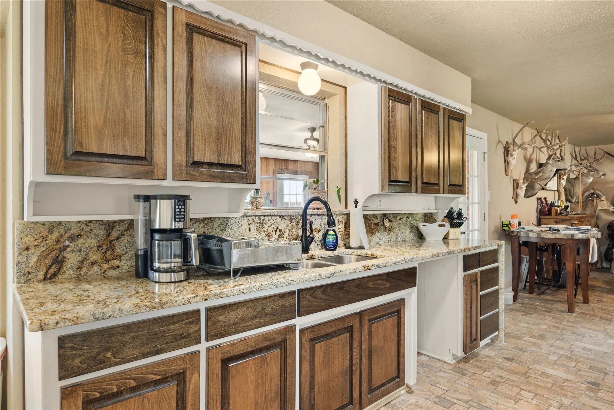 Kitchen with light stone counters, sink, and backsplash